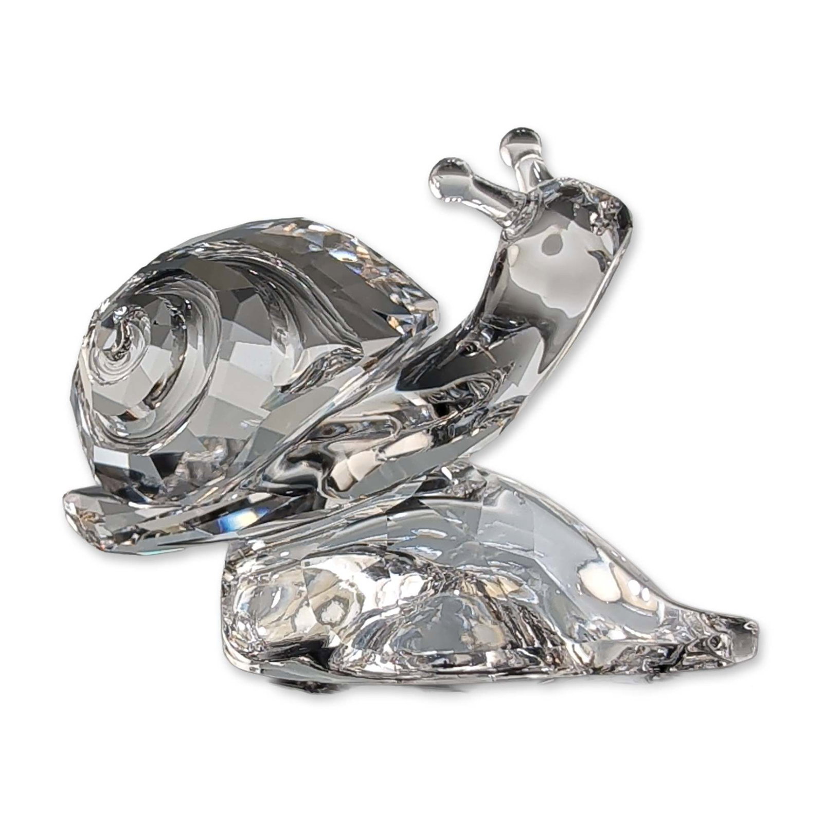 Swarovski Crystal Snail on Leaf Figurine with Box: Swarovski Snail figurine in faceted and polished lead crystal, featuring a faceted shell and smooth body with two extended antennae. Marked with the Swarovski logo on the leaf. Accompanied by the