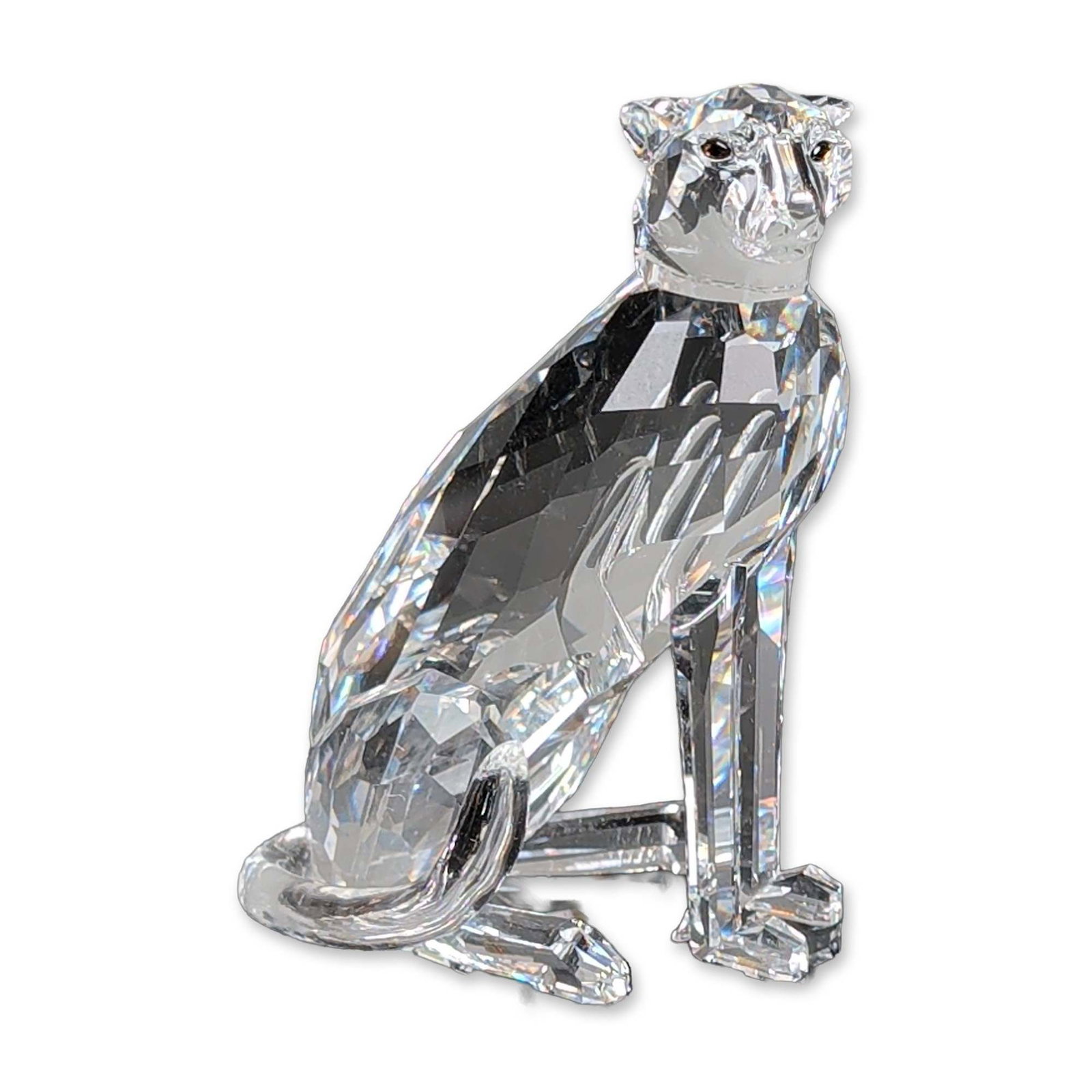 Swarovski Silver Crystal Figurine, Cheetah Var.1 Low Tail: Swarovski Silver Crystal figurine, Cheetah with low tail, designed by Michael Stamey for the African Wildlife series. The clear faceted lead crystal body is depicted in a sitting pose with a smooth cu