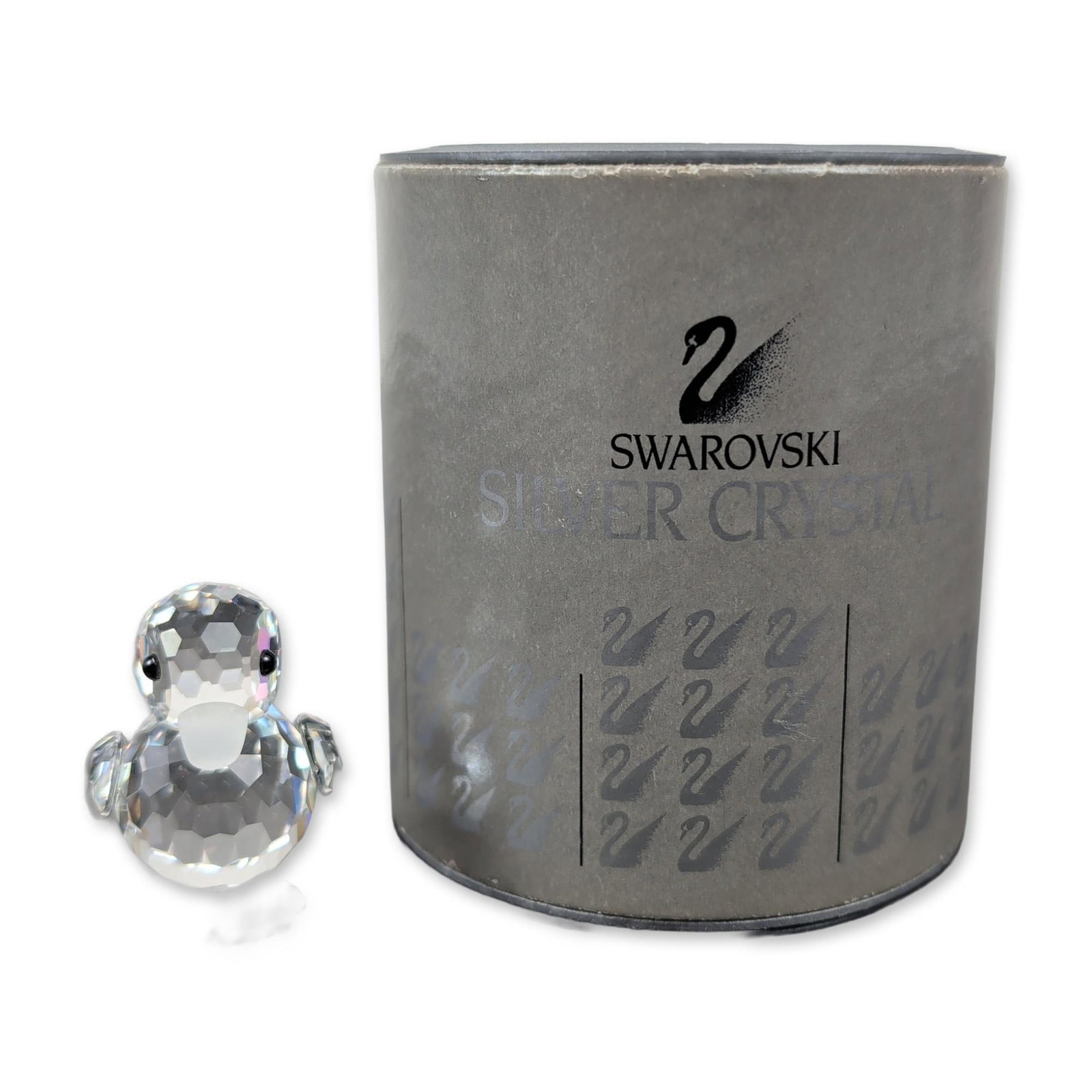 Swarovski Silver Crystal Mini Duck Figurine: Part of the Beauties of the Lake theme group, this duck features a dazzling clear crystal faceted body, striking black eyes, and frosted bill and feet. It comes with its original grey cylindrical pres