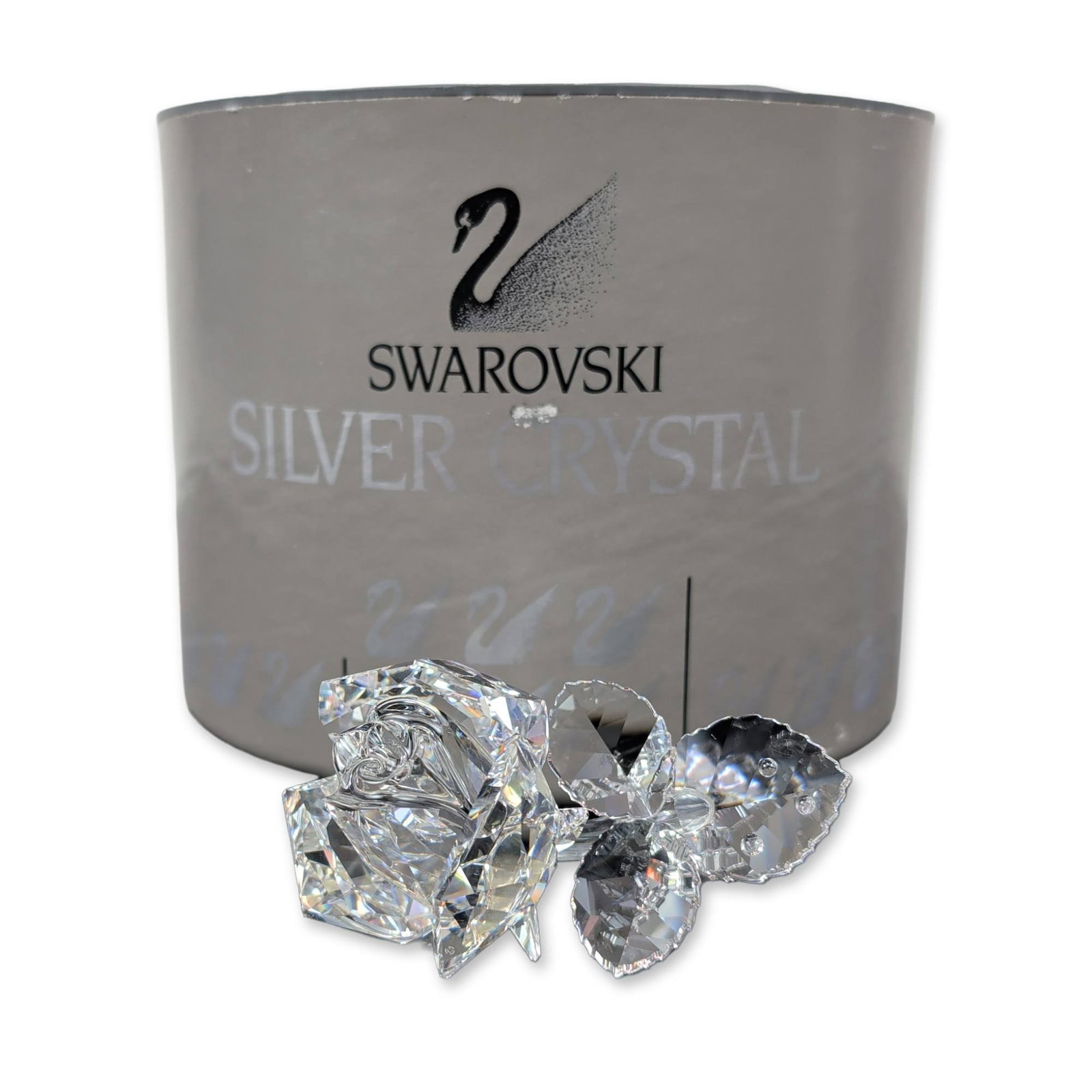 Swarovski Silver Crystal Rose Blossom Figurine: Swarovski Austrian faceted lead crystal figurine of a rose blossom, part of the Silver Crystal collection. The clear crystal piece depicts a single open rose on a curved stem with three faceted leaves