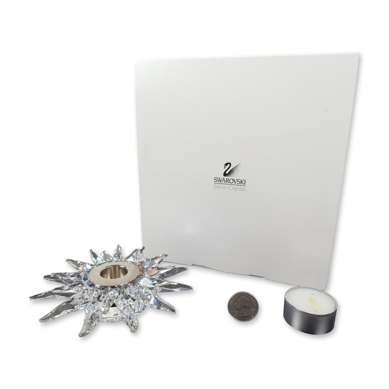 Swarovski Solaris Crystal Tea Light Candle Holder: Swarovski Solaris pattern tea light candle holder in faceted lead crystal, featuring a sunburst form with radiating points. The central well is fitted with a polished metal ring accented by small mult