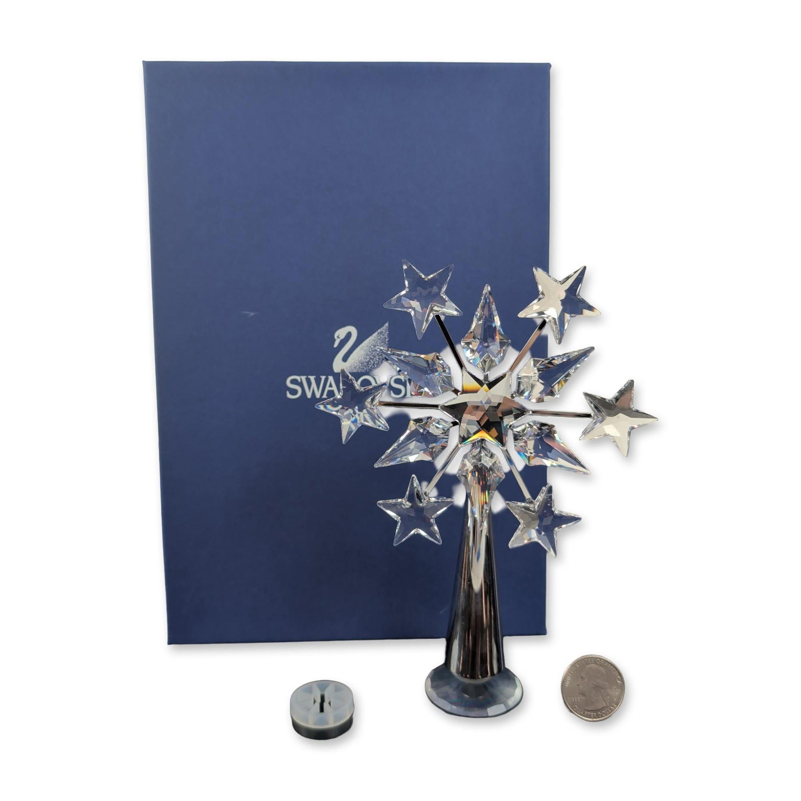 Swarovski 2003 Crystal Chrome Plated Tree Topper: This Christmas tree topper is crafted from lead crystal and chrome-plated metal, showcasing a multi-faceted snowflake design with a central five-pointed star and six radiating arms adorned with facete