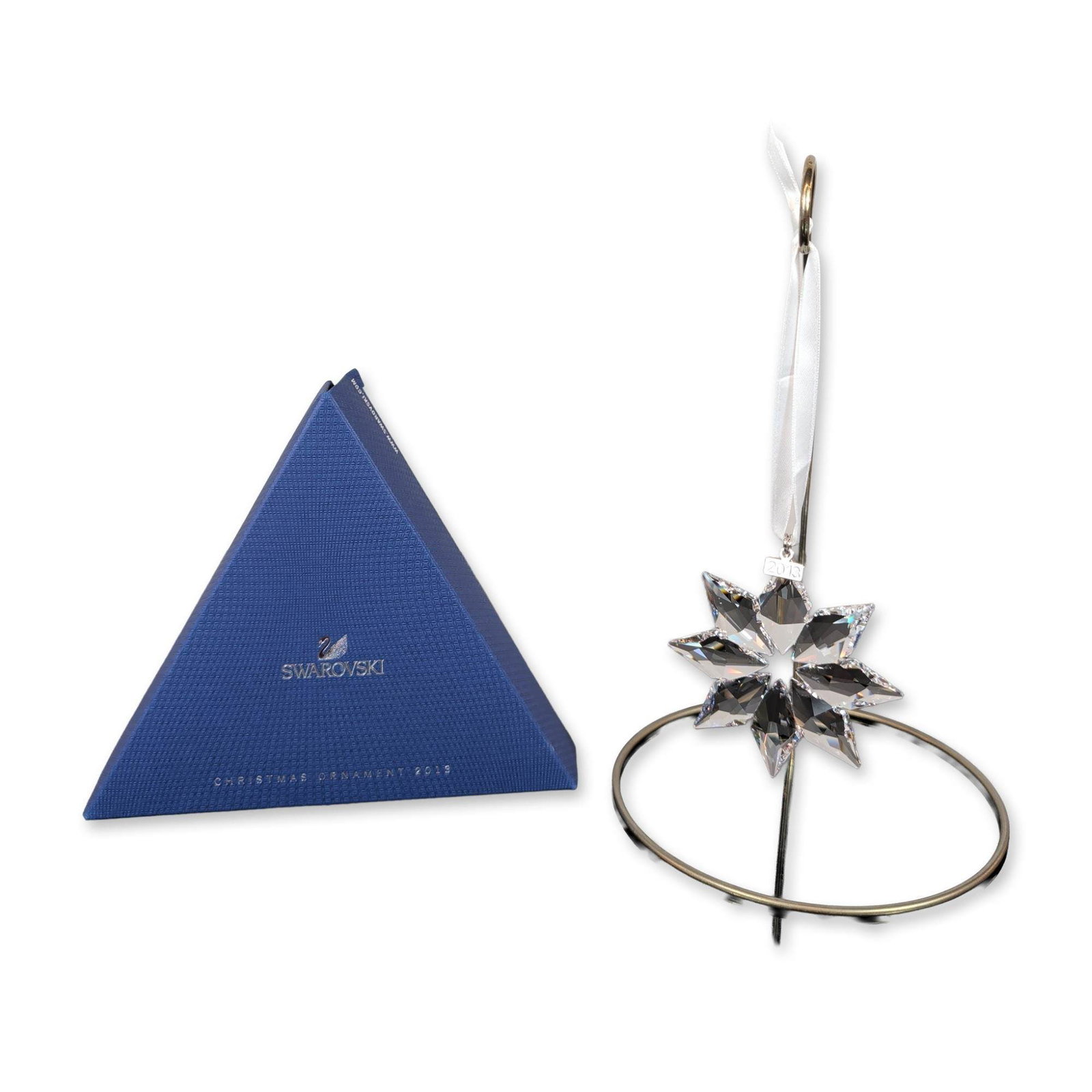 Swarovski 2013 Annual Edition Crystal Ornament: Swarovski 2013 Annual Edition Christmas ornament. Faceted clear lead crystal eight-pointed star suspended from a white satin ribbon. Metal hardware at the top of the crystal is stamped with the Swarov