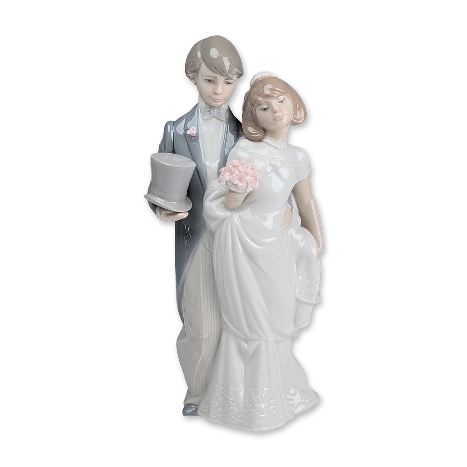 Lladro Glazed Porcelain Figurine, Wedding Bells 01006164: Glazed porcelain figurine titled Wedding Bells designed by sculptor Juan Huerta. The piece depicts a bride and groom in formal wedding attire; the bride wears a white gown with textured floral embroid