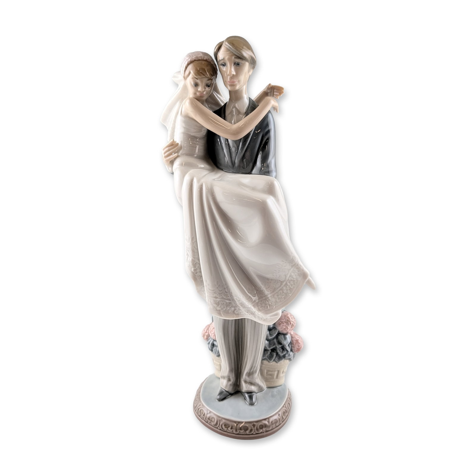 Lladro Porcelain Over the Threshold Figurine: Lladro glazed porcelain figurine, titled Over the Threshold, model number 5282. This piece, designed by Juan Huerta and issued in 1985, depicts a groom in a formal black tuxedo with pinstriped trouser