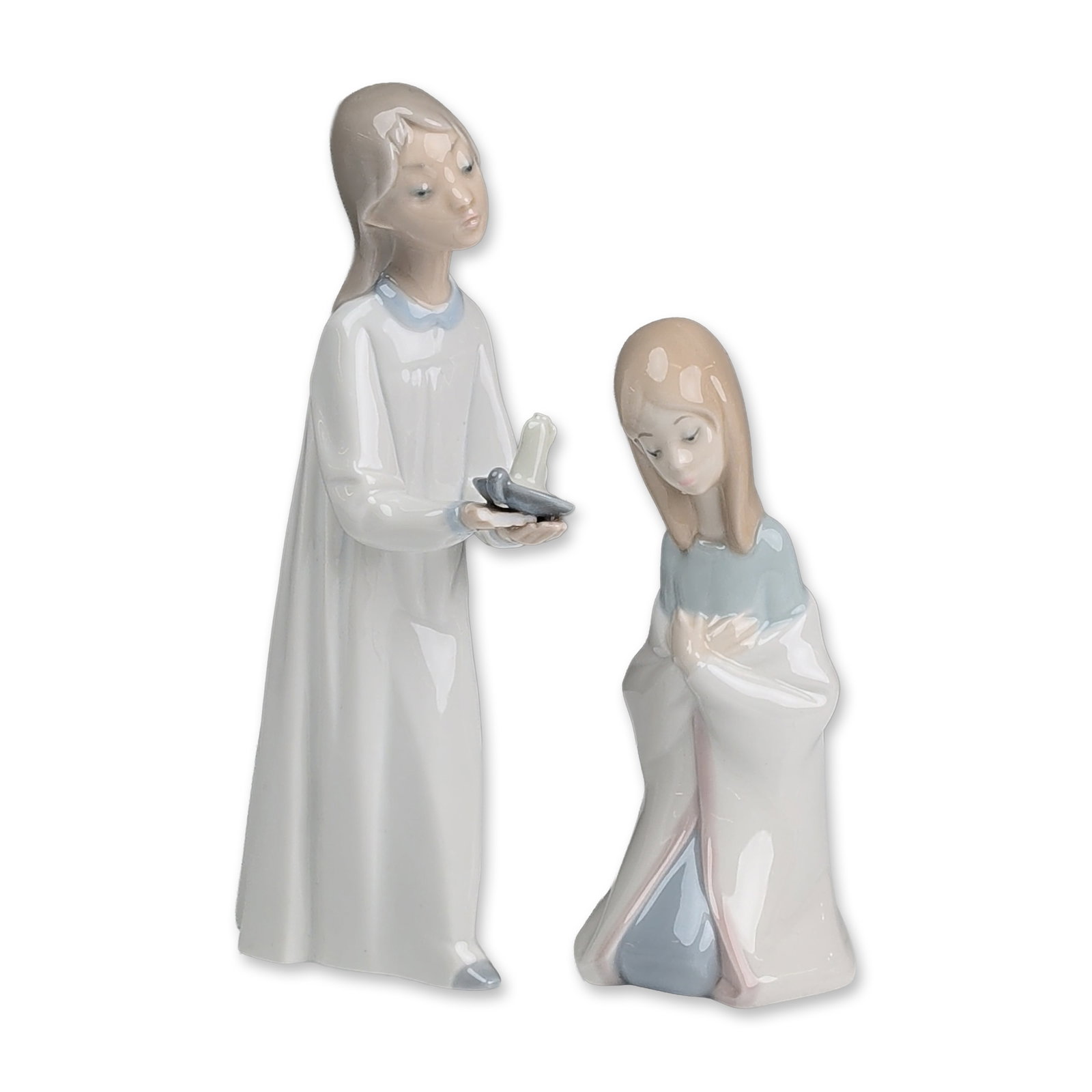 2pc Lladro Glazed Porcelain Girl Figurines, Girl with Candle & Mary: Glazed porcelain figurines depicting two young girls one in a long white gown with a light blue collar, holding a chamberstick with a candle - Girl with Candlestick 4868. The second figure is depicted