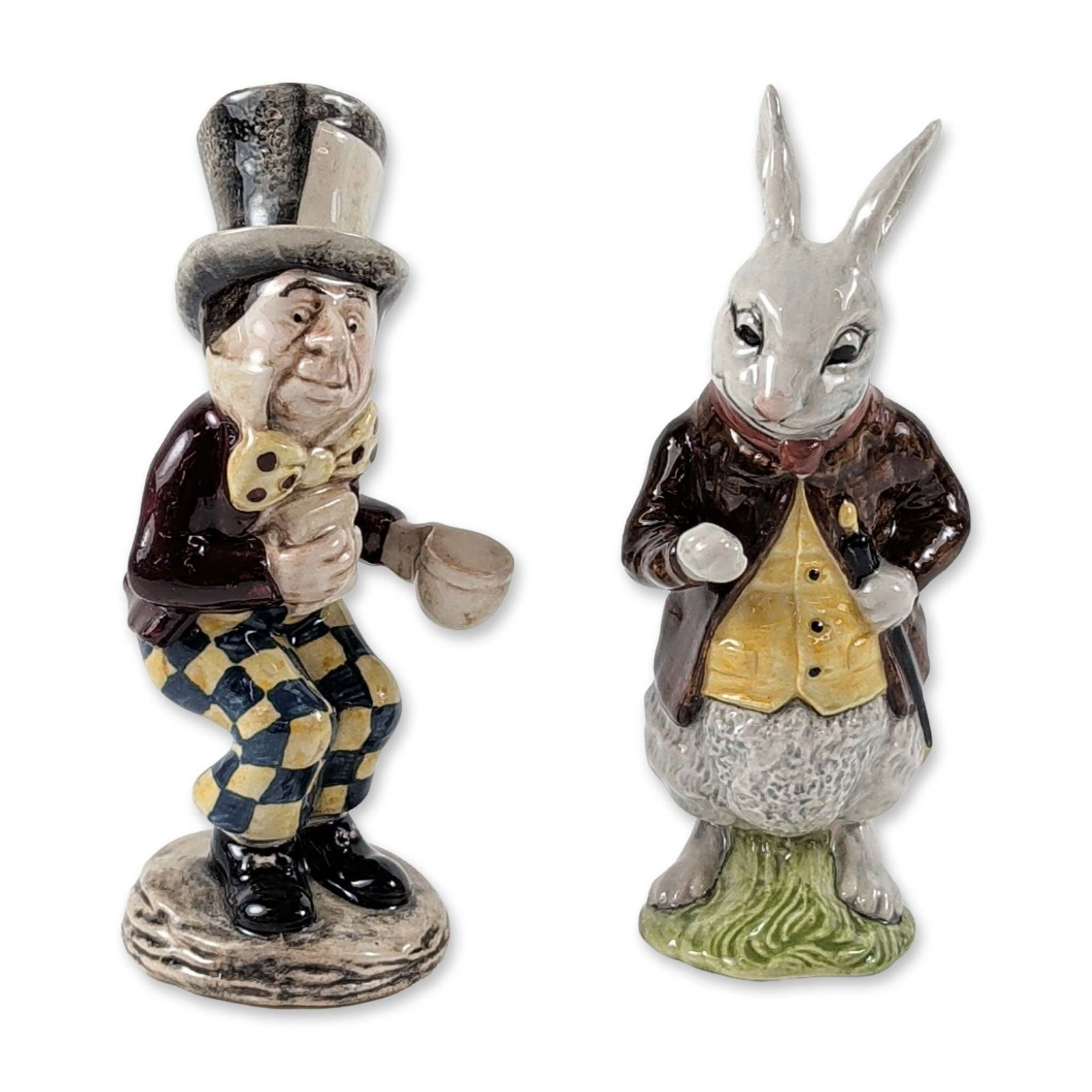2pc Beswick Alice Series Ceramic Figurines: Beswick (England, 1974). Pair of figurines in glazed ceramic, featuring the characters White Rabbit and Mad Hatter from the Alice Series. Visual details include the White Rabbit on a green base in a b