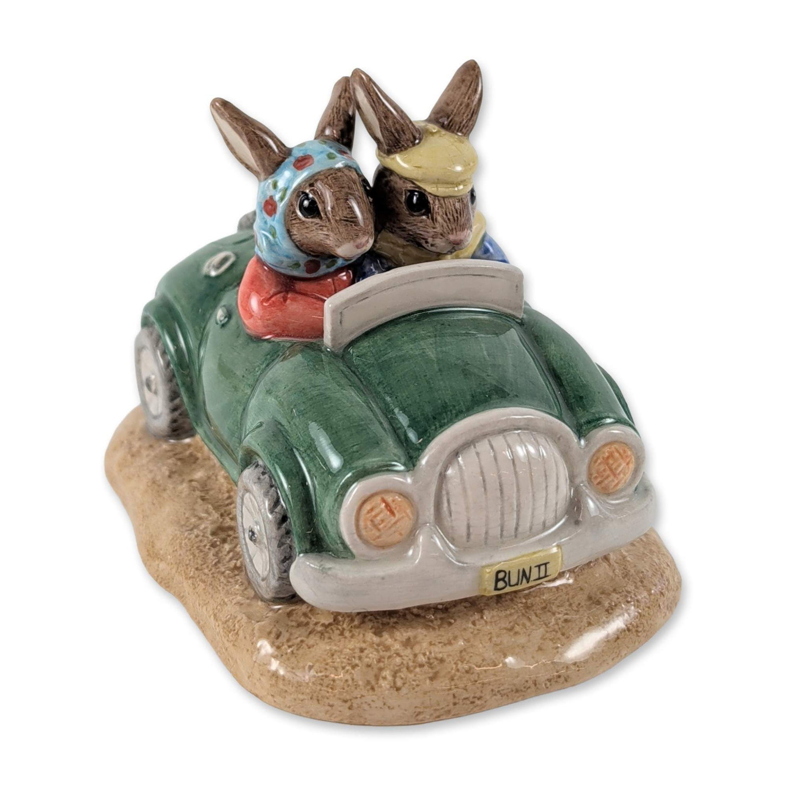 Royal Doulton Limited Edition Day Trip Bunnykins DB260 Ceramic Figurine: Royal Doulton Day Trip Bunnykins figurine, model DB260, hand-decorated glazed ceramic. The piece depicts two anthropomorphic rabbits in a green open-top vintage motor car set upon a textured sand-colo