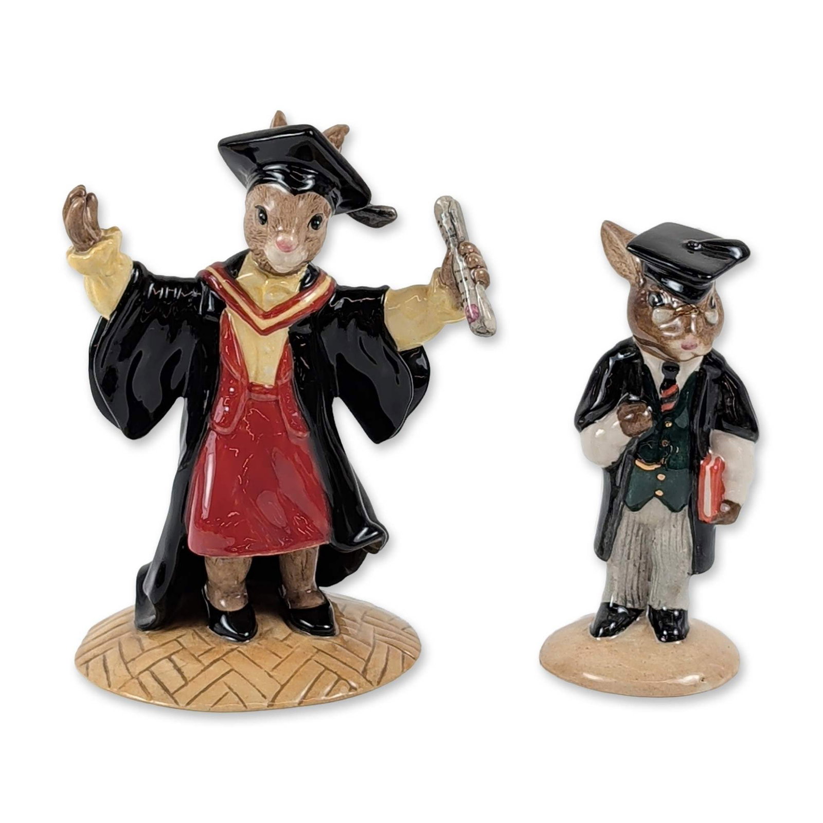 Pair of Royal Doulton Bunnykins Academic Ceramic Figurines: Pair of Royal Doulton hand-decorated glazed ceramic figurines from the Bunnykins series, including "Graduation Time" and "Schoolmaster Bunnykins." The Graduation Time figurine (DB 329) features an ant