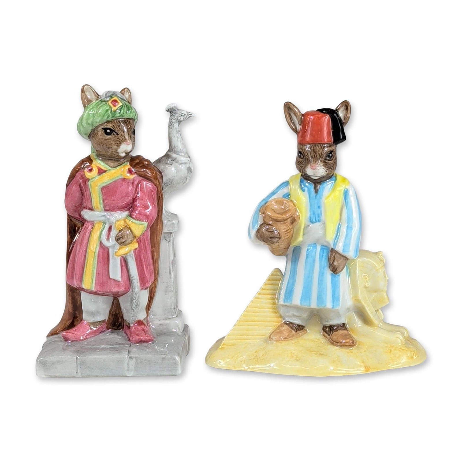 2pc Royal Doulton Bunnykins Egyptian and Arabian Figurines: Pair of Royal Doulton Bunnykins glazed ceramic figurines including Egyptian Bunnykins (DB 314) and Arabian Nights Bunnykins (DB 315). The Egyptian figure is modeled as a rabbit in a blue and yellow st