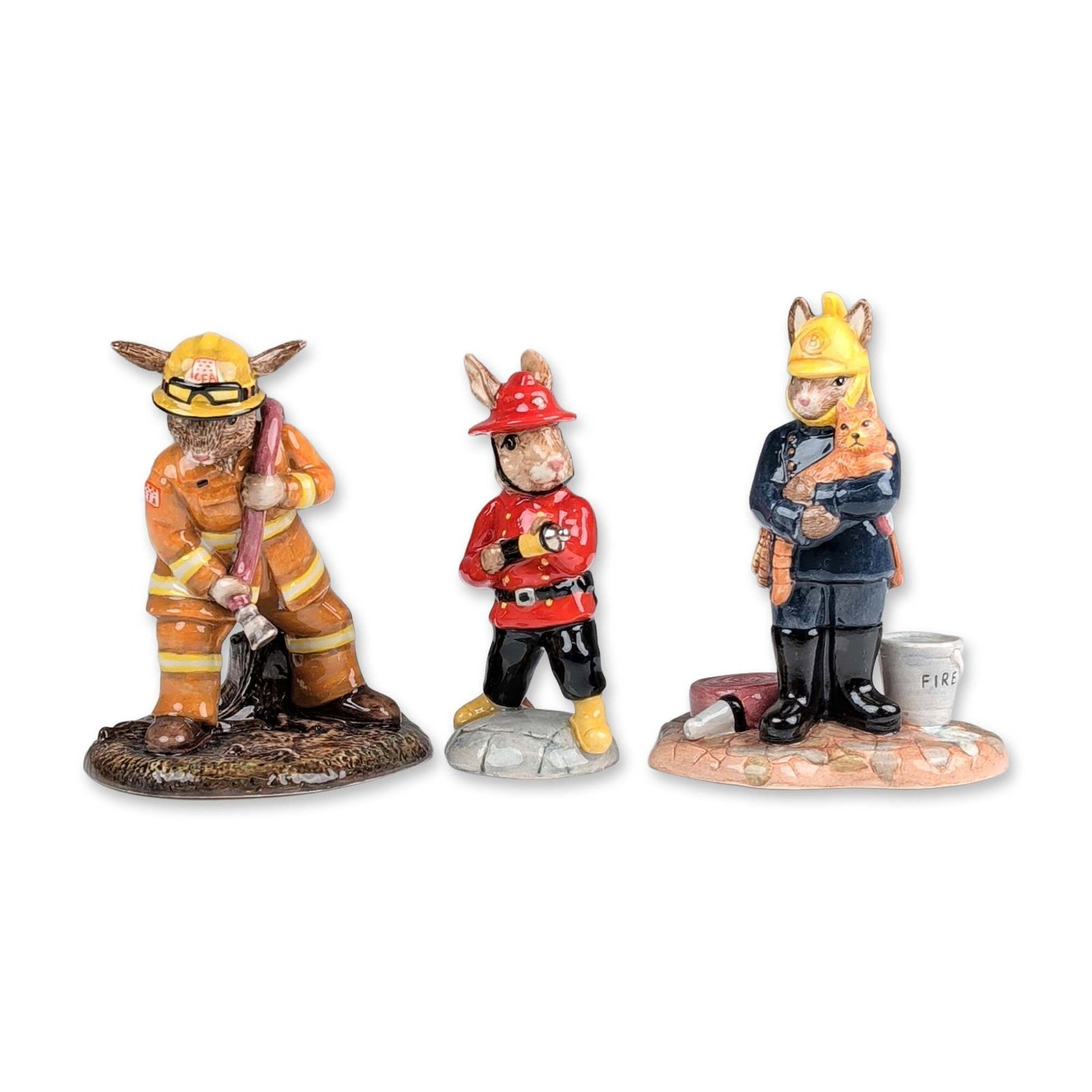 3pc Royal Doulton Bunnykins Firefighter Figurines: Royal Doulton. Trio of hand-decorated glazed ceramic figurines from the Bunnykins series, depicting rabbits in various firefighting uniforms. The group includes a Professions Collection Fireman in a b
