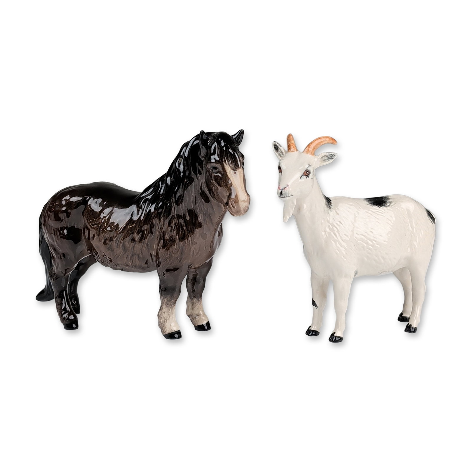 2pc Royal Doulton Animal Figurines: Including a standing goat and a pony. The goat is modeled with a white coat, black patches, and tan-colored horns, featuring a blue underglaze crown mark on the underside. The pony is finished in a da