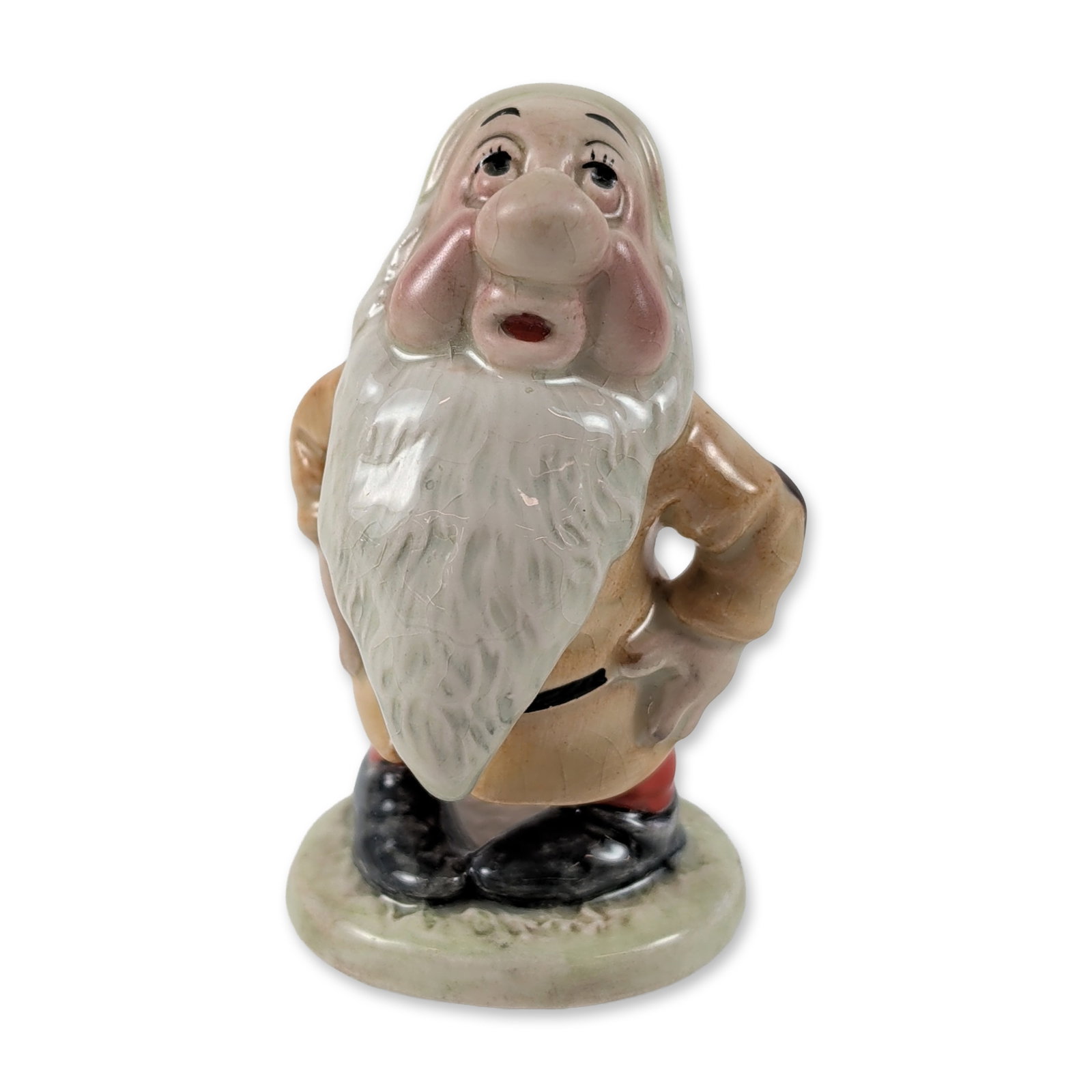 Beswick Disney Sleepy Glazed Ceramic Figurine: Beswick, England. Glazed ceramic figurine of the character Sleepy from Walt Disney's Snow White and the Seven Dwarfs. Hand-painted decoration features a tan tunic with a black belt, red trousers, and 