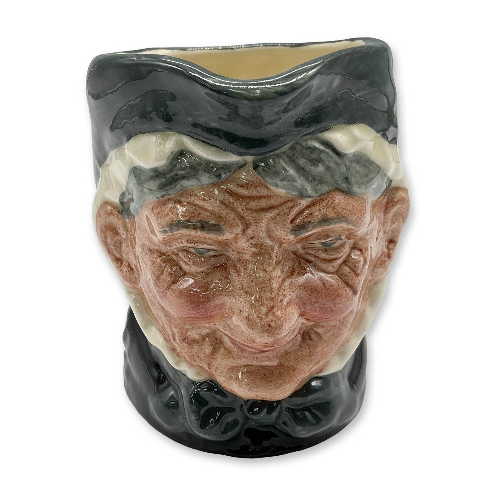 Granny D6384 - Small - Royal Doulton Character Jug: Style One, Toothless Granny. Dark green and white coloration. Royal Doulton backstamp. Artist: Harry Fenton Dimensions: 3.25"H Date or Era: 1935 Manufacturer or Brand: Royal Doulton Country of Ori