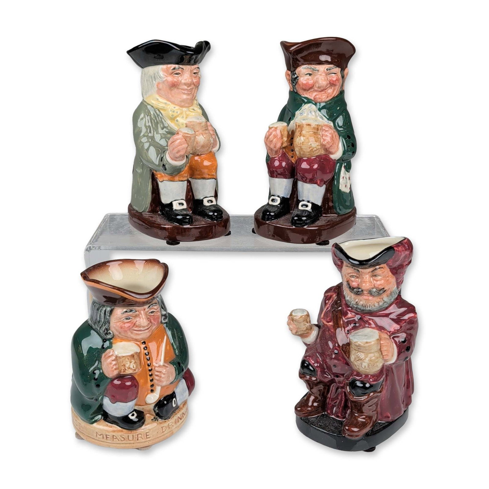 4pc Royal Doulton Toby Jugs: Royal Doulton, England. Set of four seated character Toby jugs in glazed ceramic, each depicting a figure holding a mug. The collection includes Sir John Falstaff in a red coat and black tricorn hat, 