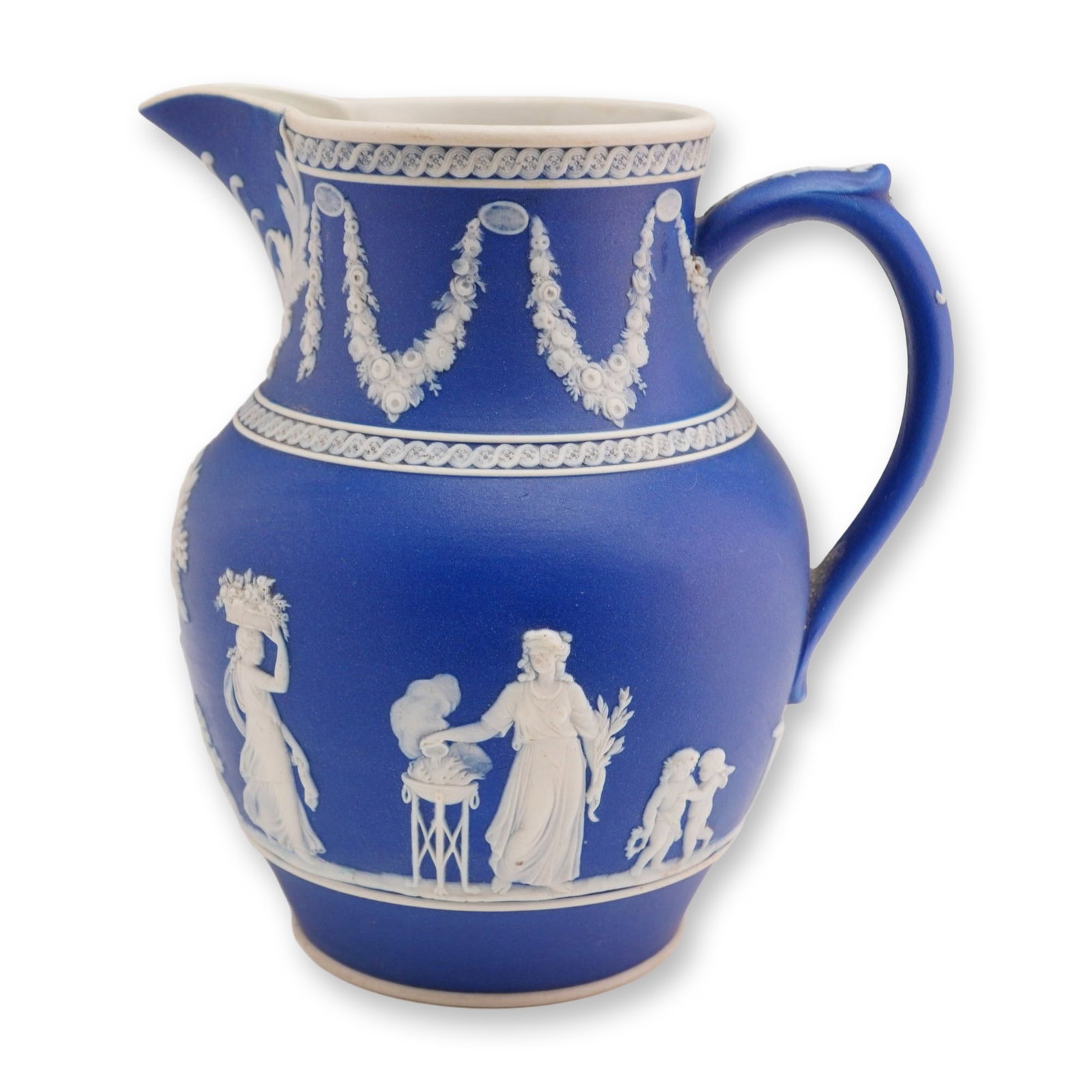 Wedgwood Cobalt Blue Jasperware Pitcher with Classical White Reliefs: A Wedgwood jasperware pitcher in a deep cobalt blue stoneware featuring applied white sprigged relief decoration. The bulbous body is ornamented with various classical scenes, including draped female 