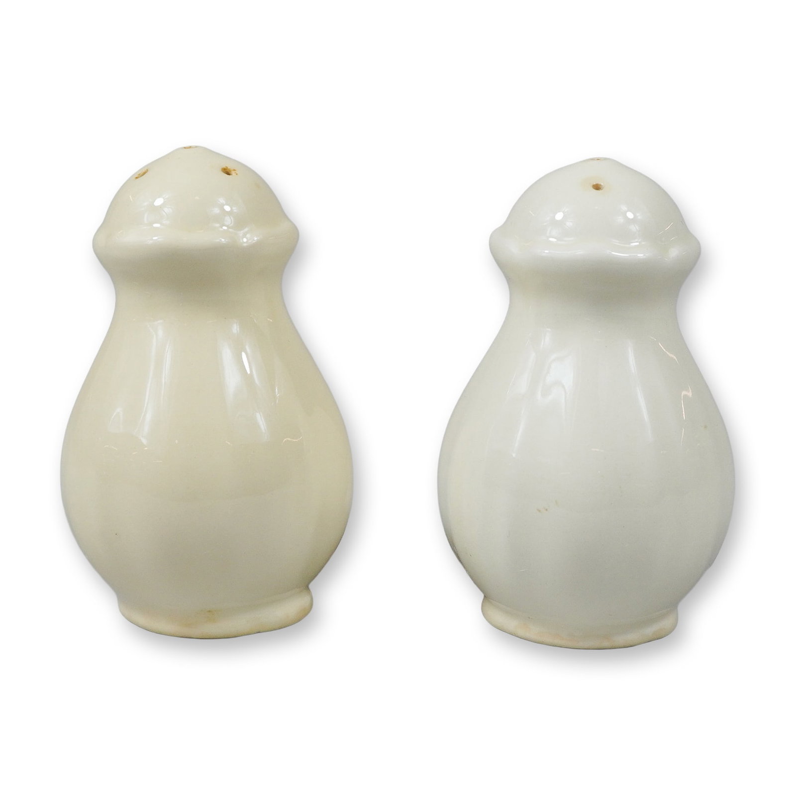 A Pair of Wedgwood Creamware Salt and Pepper Shakers: A pair of Wedgwood earthenware salt and pepper shakers. These shakers are made of creamware, also known as Queen's Ware, and feature a baluster-form body with vertical fluting and a domed top. They ar