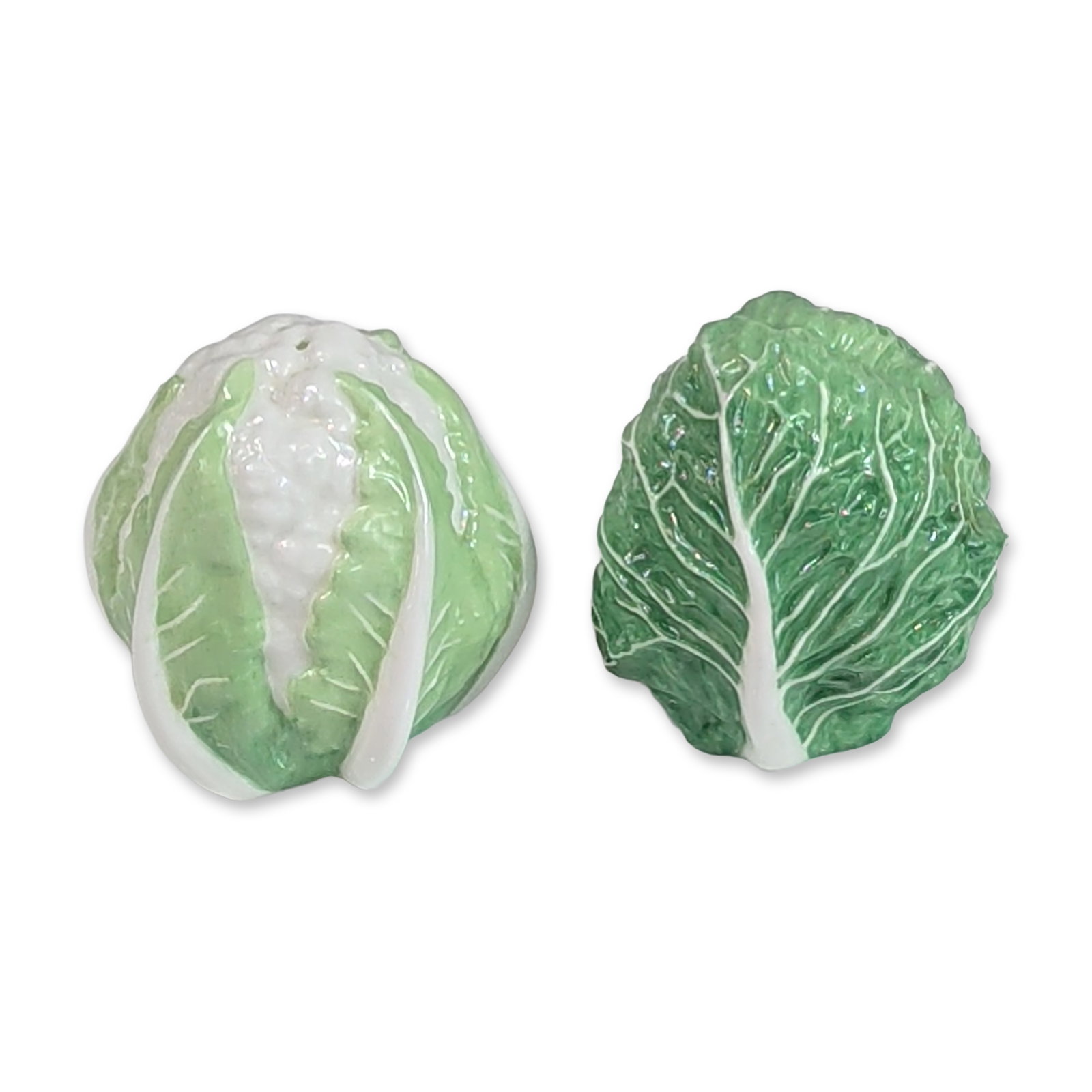 2pc Wedgwood Ceramic Cabbage and Cauliflower Shakers: A pair of salt and pepper shakers in glazed ceramic, realistically modeled as a green savoy cabbage and a cauliflower head. The cabbage shaker is textured with prominent white veining against a deep g