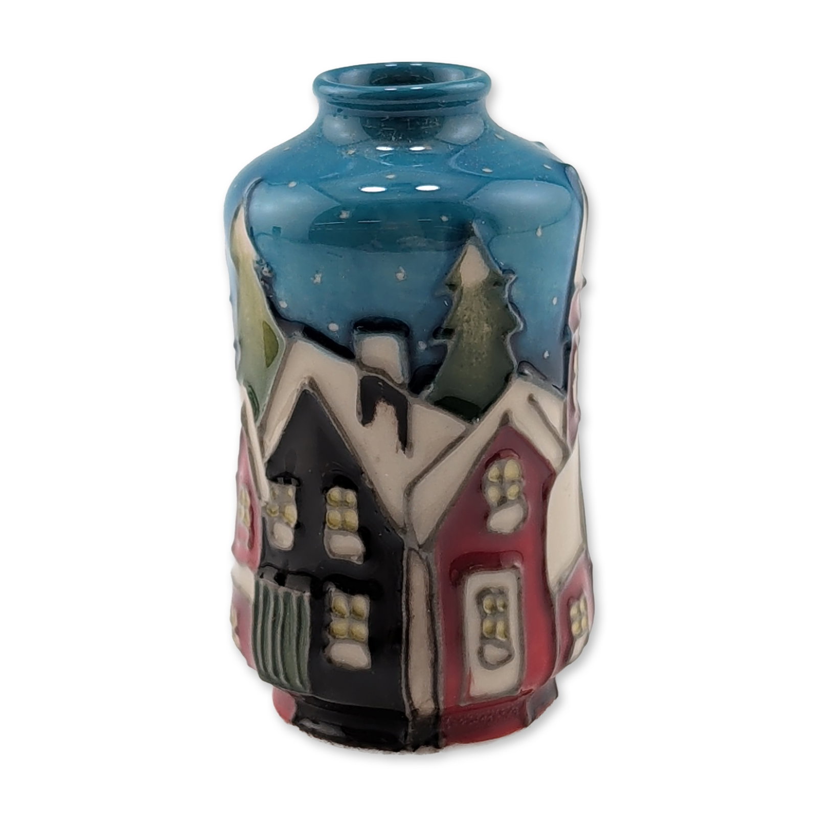 Moorcroft Pottery Miniature Vase, Snow Chimneys: Studio pottery miniature bulbous vase with a short, flared rim. The ceramic body features tubelined relief decoration depicting a stylized winter village scene under a dark blue snowy sky, including g