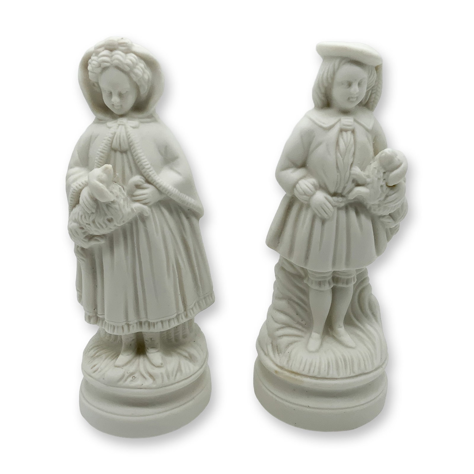 Pair of Bisque Porcelain Figurines: A collectible highlighting Pair of Bisque Porcelain Figurines. Pair of bisque porcelain figurines showcasing a girl with a lamb and a boy with a bird. Detailed Victorian-style design with a matte fini