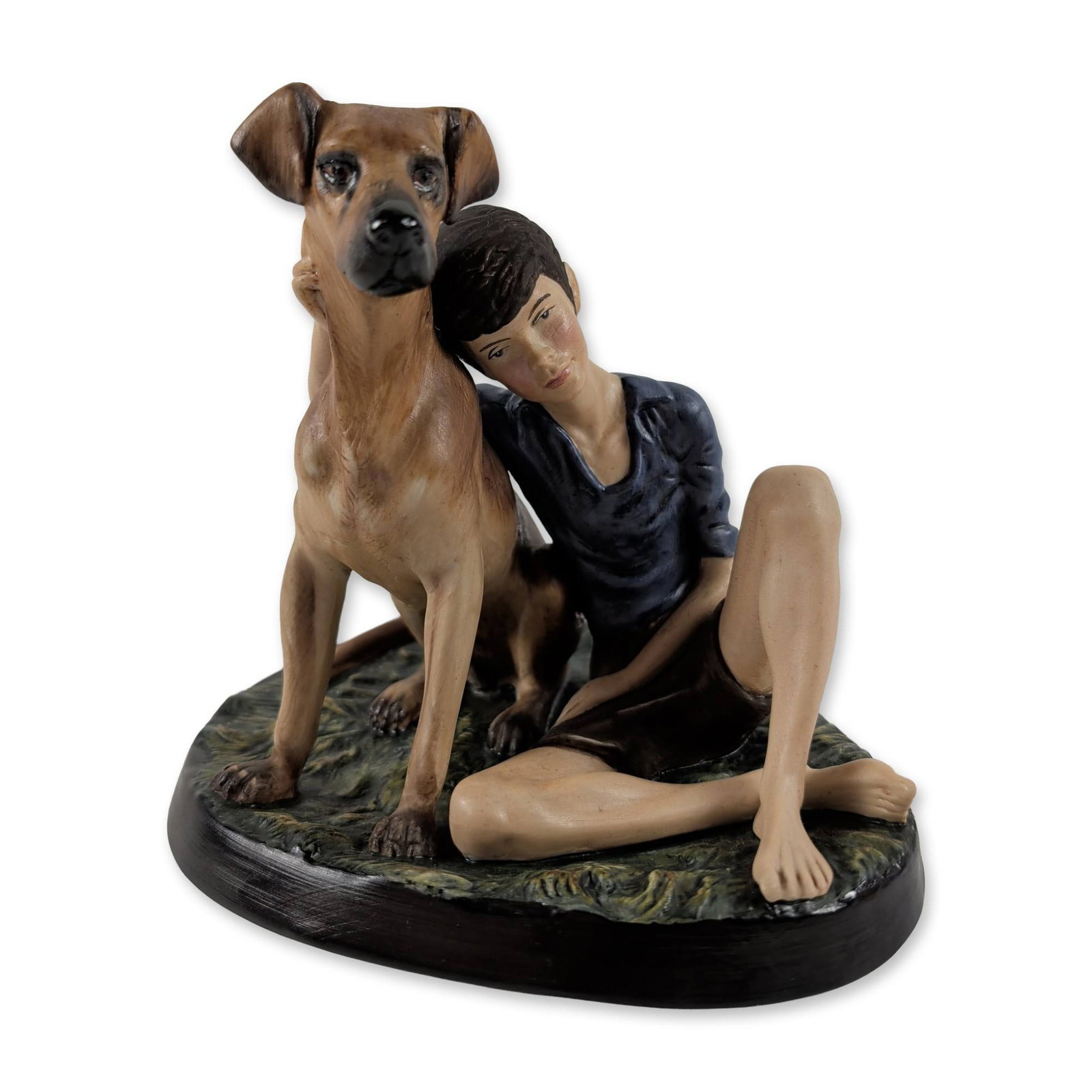 Royal Doulton Buddies HN 2546 Porcelain Figurine: Royal Doulton. Buddies figurine, model HN 2546, in hand-painted porcelain with a matte finish. The composition depicts a young boy in a blue shirt and dark shorts seated on a textured green base besid
