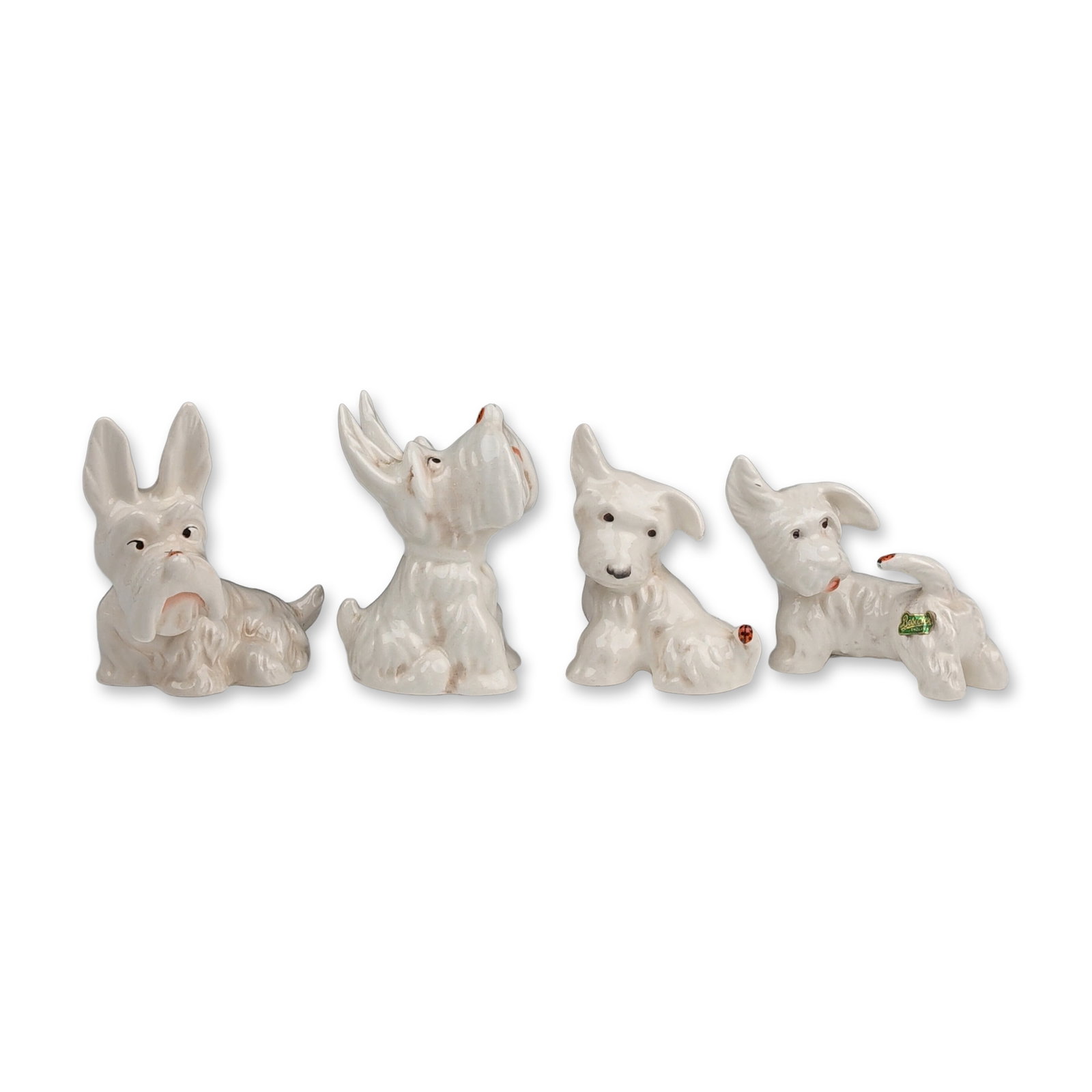 4pc Beswick Westie Figurines: Beswick, England. Group of four white glazed ceramic figurines depicting West Highland White Terriers in assorted poses, including standing and begging positions. Features molded textural details repr