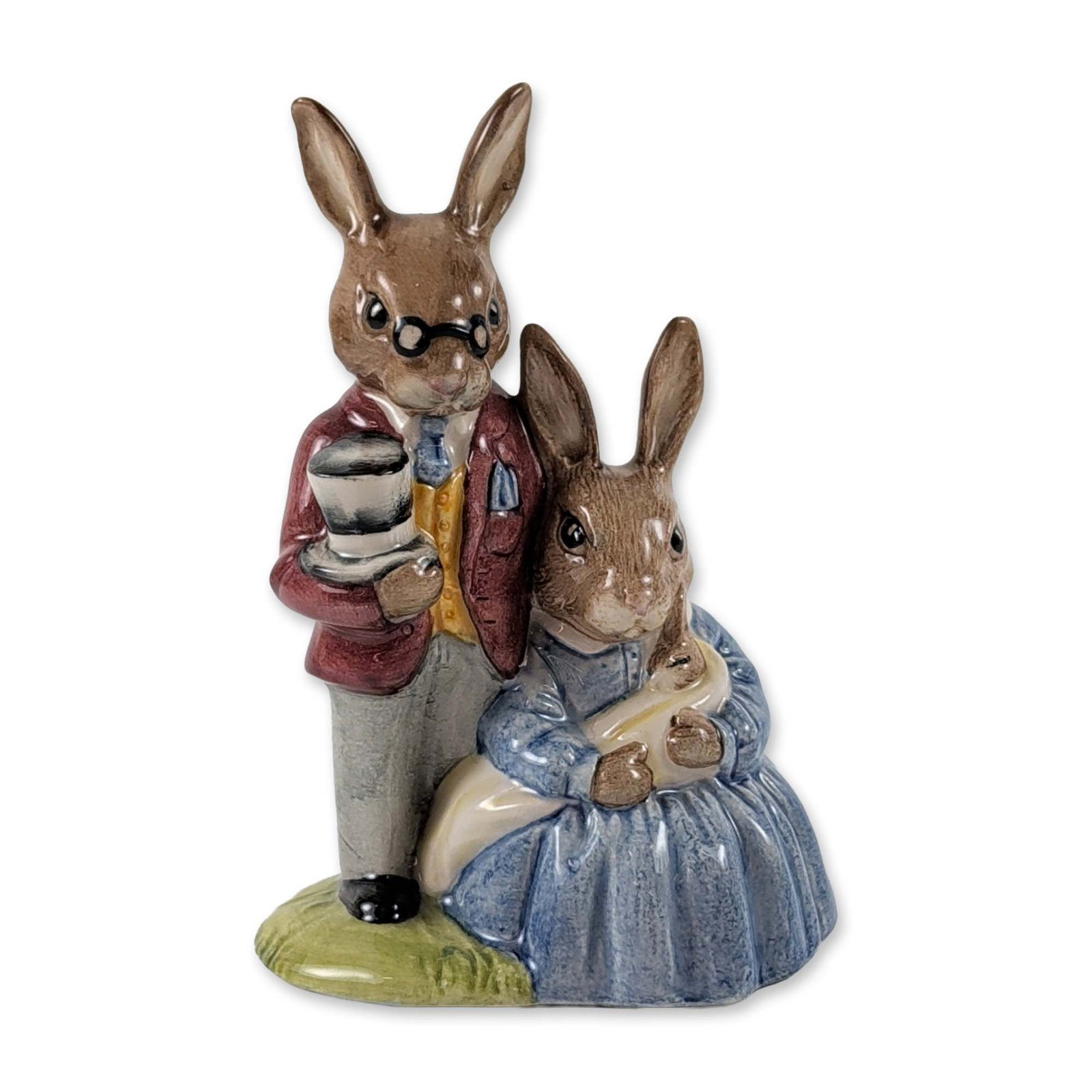 Royal Doulton Bunnykins Family Figurine DB68: Royal Doulton Bunnykins glazed porcelain figurine titled Father, Mother and Victoria. The piece depicts an anthropomorphic rabbit family group with the father rabbit wearing spectacles and a maroon ja