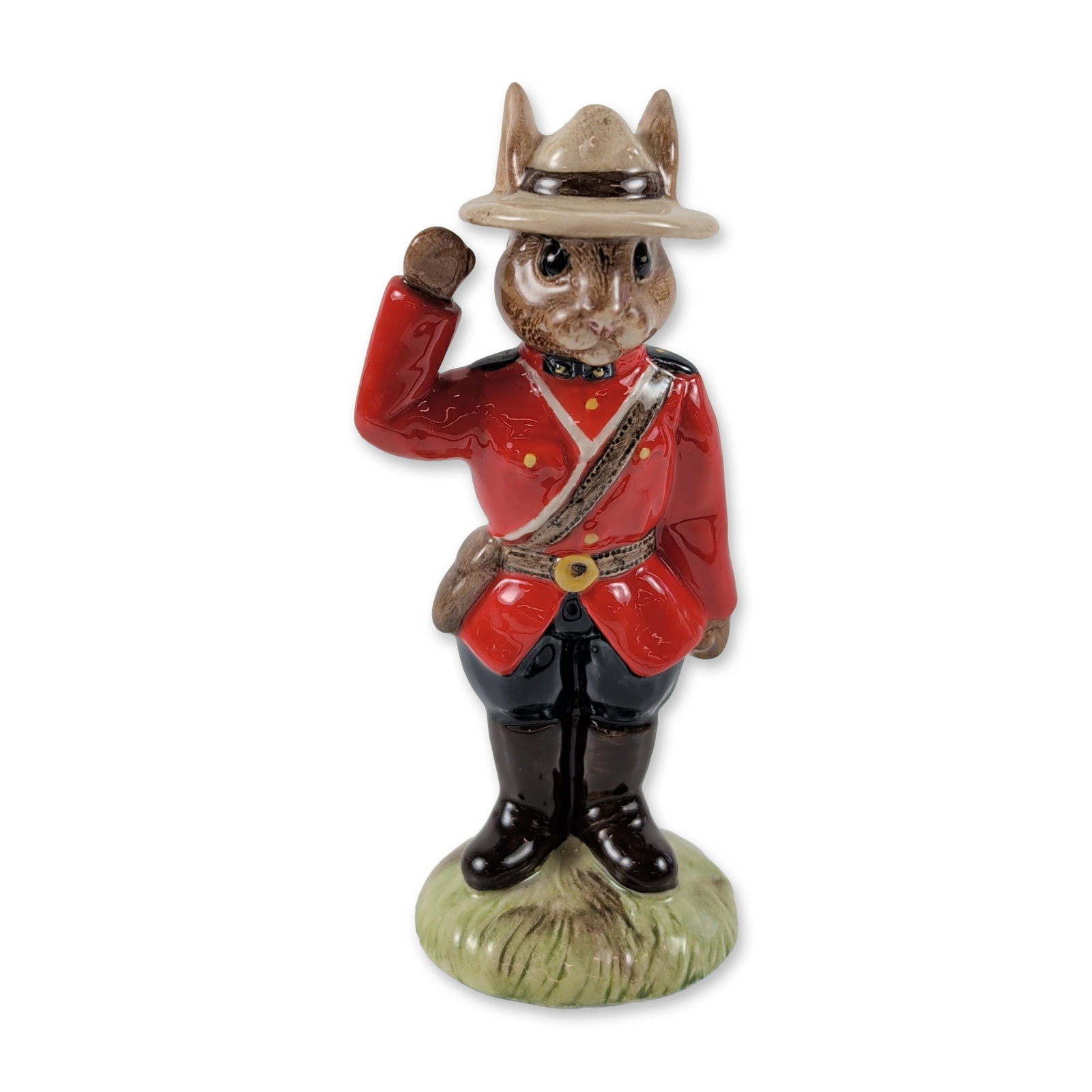 Royal Doulton Mountie Bunnykins Ceramic Figurine: Royal Doulton. Mountie Bunnykins figurine in glazed ceramic, depicting a rabbit dressed in a Royal Canadian Mounted Police uniform with a red serge tunic, brown belt, and wide-brimmed hat. The figure 
