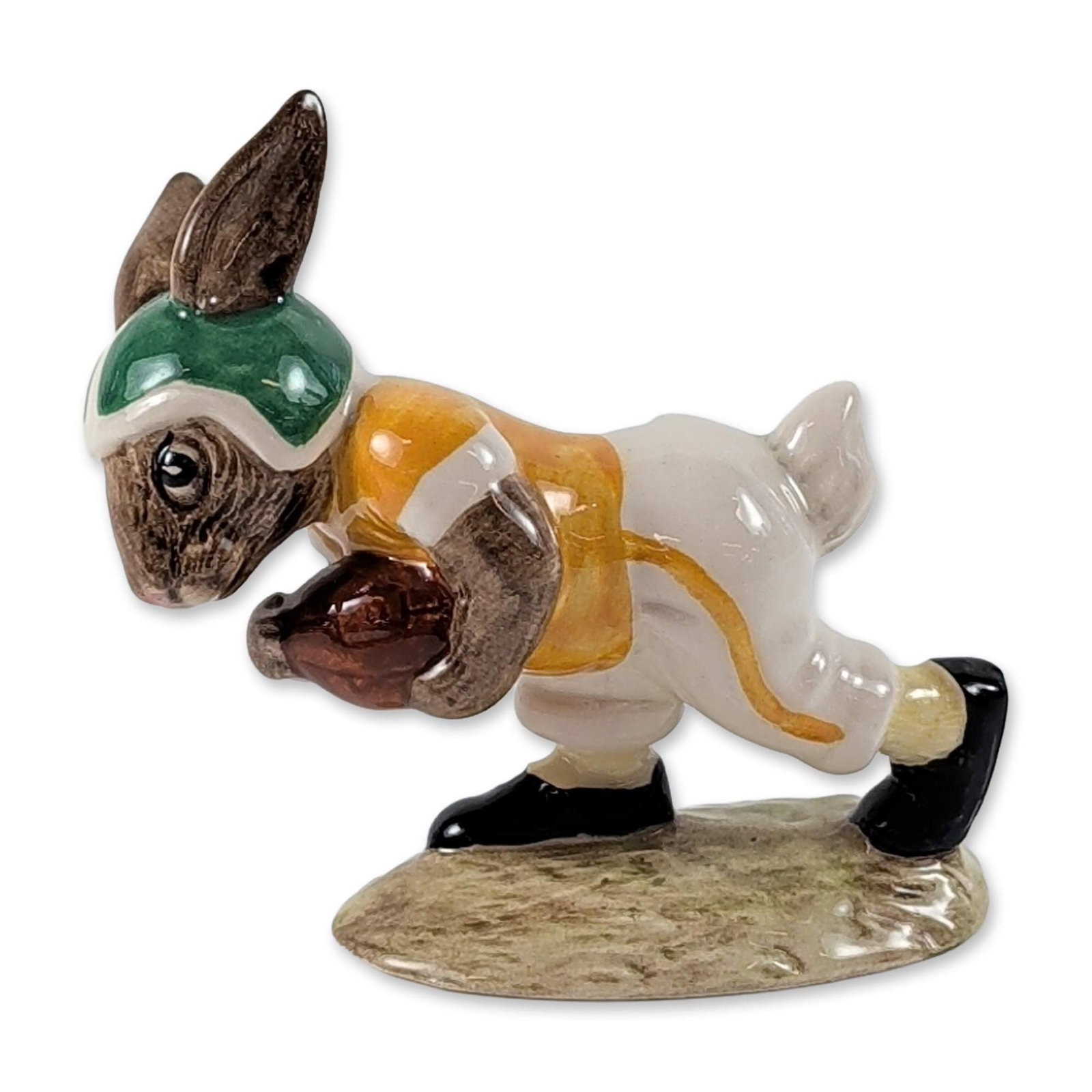 Royal Doulton Touchdown Bunnykins Figurine DB99: Royal Doulton polychrome glazed ceramic figurine from the Bunnykins series titled Touchdown Bunnykins. The figure depicts a rabbit as an American football player in a diving pose, dressed in a green h