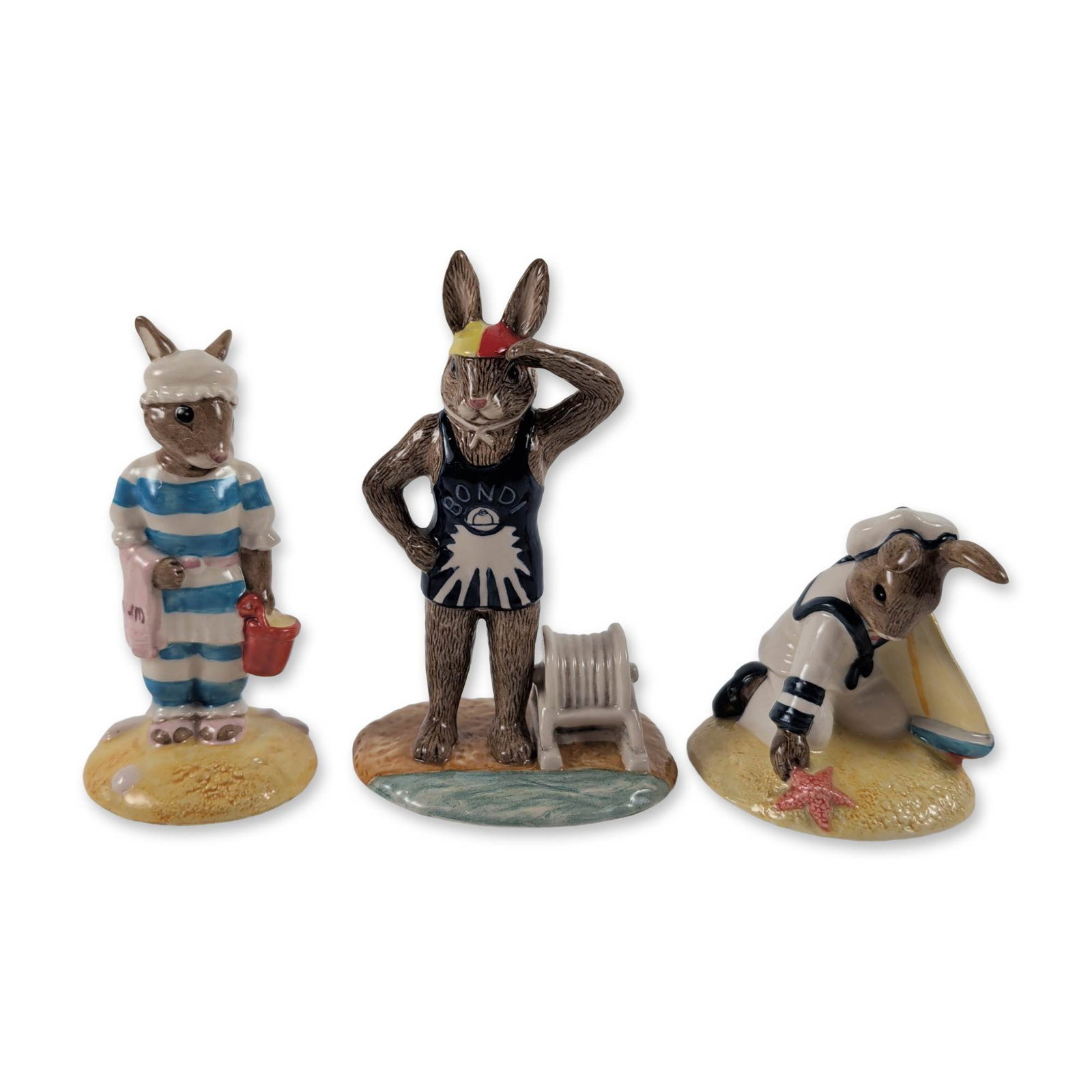 3pc Royal Doulton Bunnykins Porcelain Figurines: Royal Doulton. 3pc Bunnykins figurines in glazed porcelain featuring nautical and beach themes. Included are Sailor Bunnykins DB 166 (Bunnykins of the Year 1997), Mother Bunnykins DB 189 (Bunnykins of