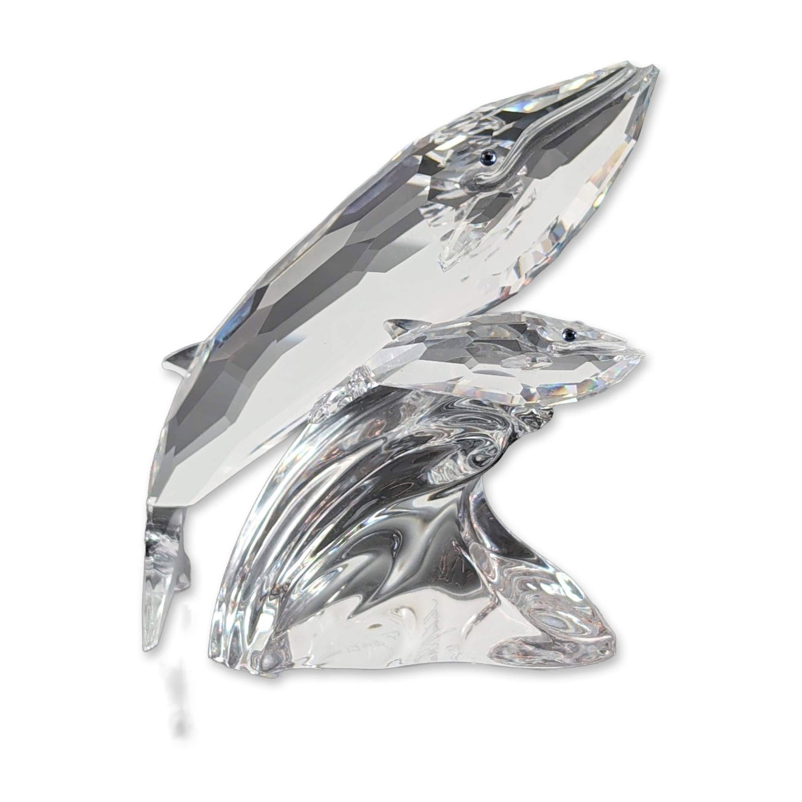 Swarovski 1992 SCS Annual Edition Whales Figurine: The sculpture depicts a breaching mother humpback whale and her calf rising from a stylized, undulating wave base. The whales are constructed from clear multi-faceted crystal with small blue inset sto