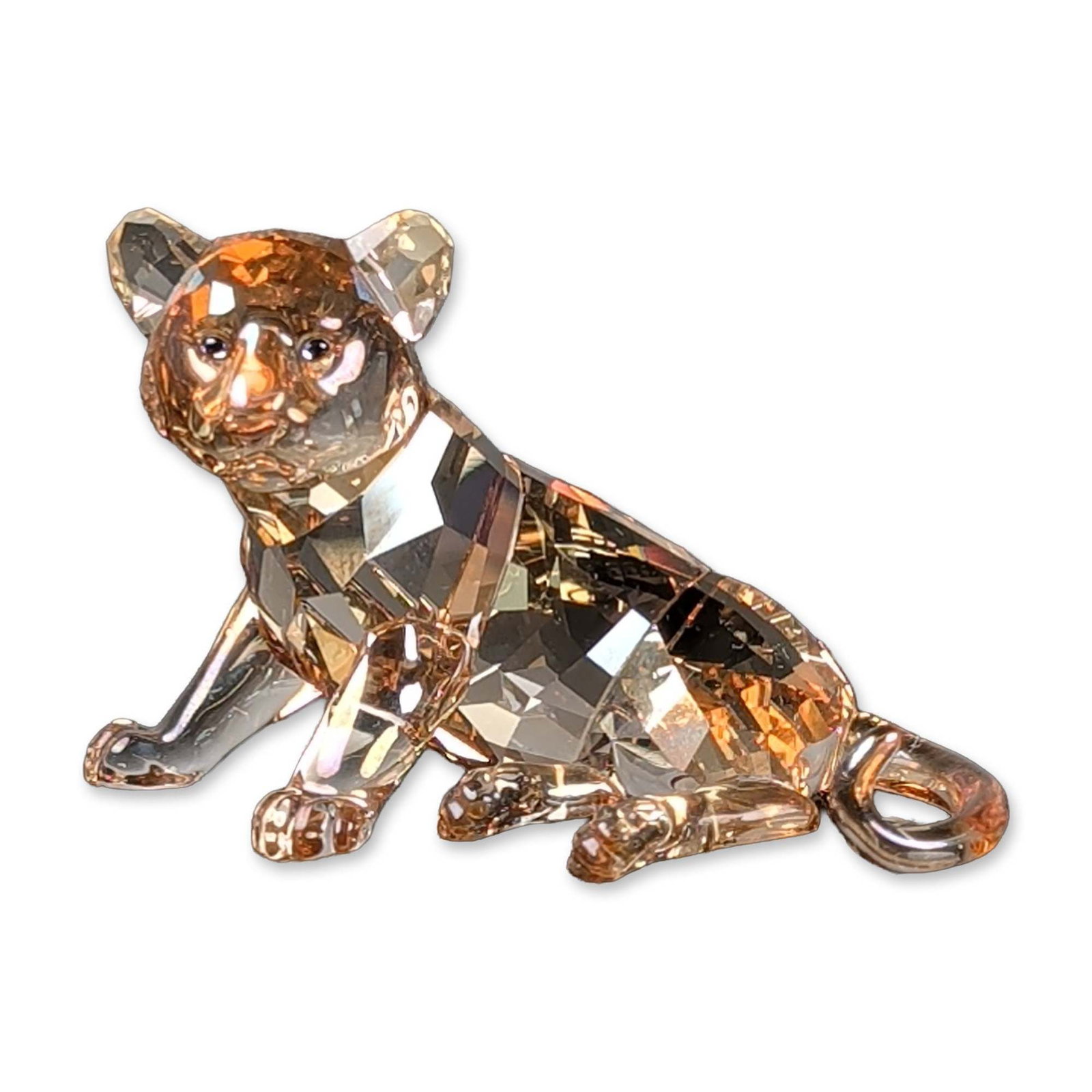 Swarovski Crystal SCS 2010 Annual Edition Figurine, Tiger Cub Sitting: The tiger cub is modeled in a sitting pose and crafted in faceted Golden Shine amber crystal with printed facial details. A laser-etched Swarovski swan logo and copyright mark are located on the upper