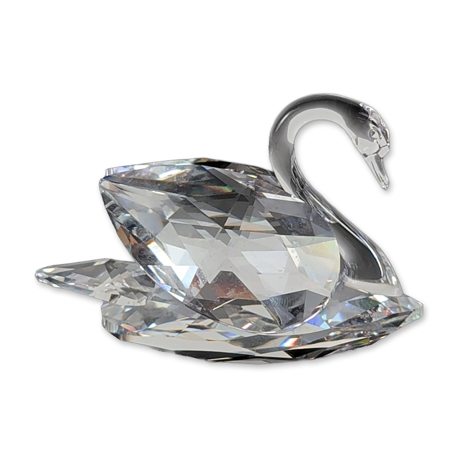 Swarovski Crystal Swan Figurine: In faceted crystal, featuring a smooth, arched neck and head with a multi-faceted body designed to refract light. The underside of the base is etched with the Swarovski swan logo and SWAROVSKI maker n
