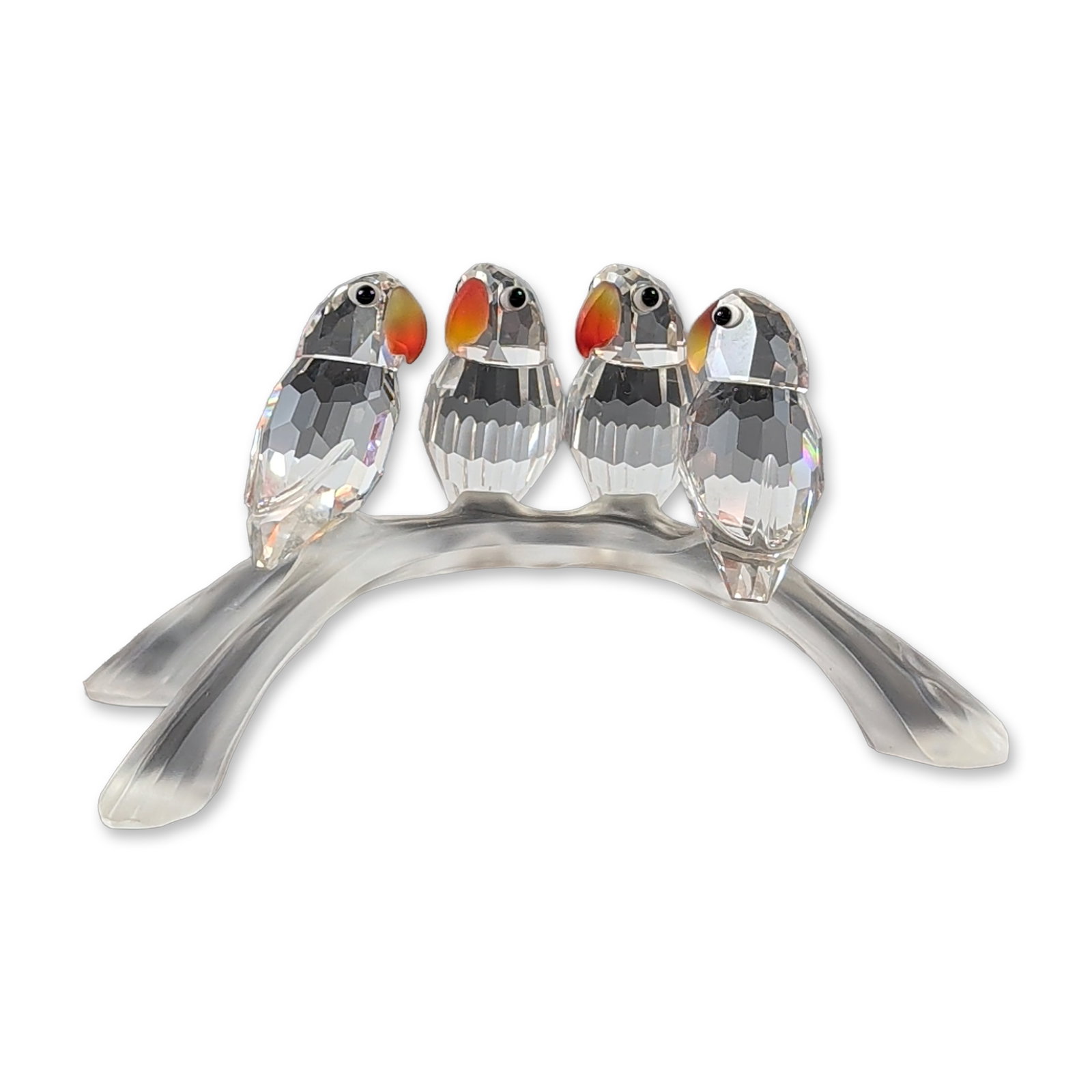 Swarovski Silver Crystal Baby Lovebirds Figurine: Swarovski Silver Crystal. Figurine in clear and colored crystal titled Baby Lovebirds. The piece features four birds with faceted bodies and yellow-orange heads perched upon a frosted crystal branch. 