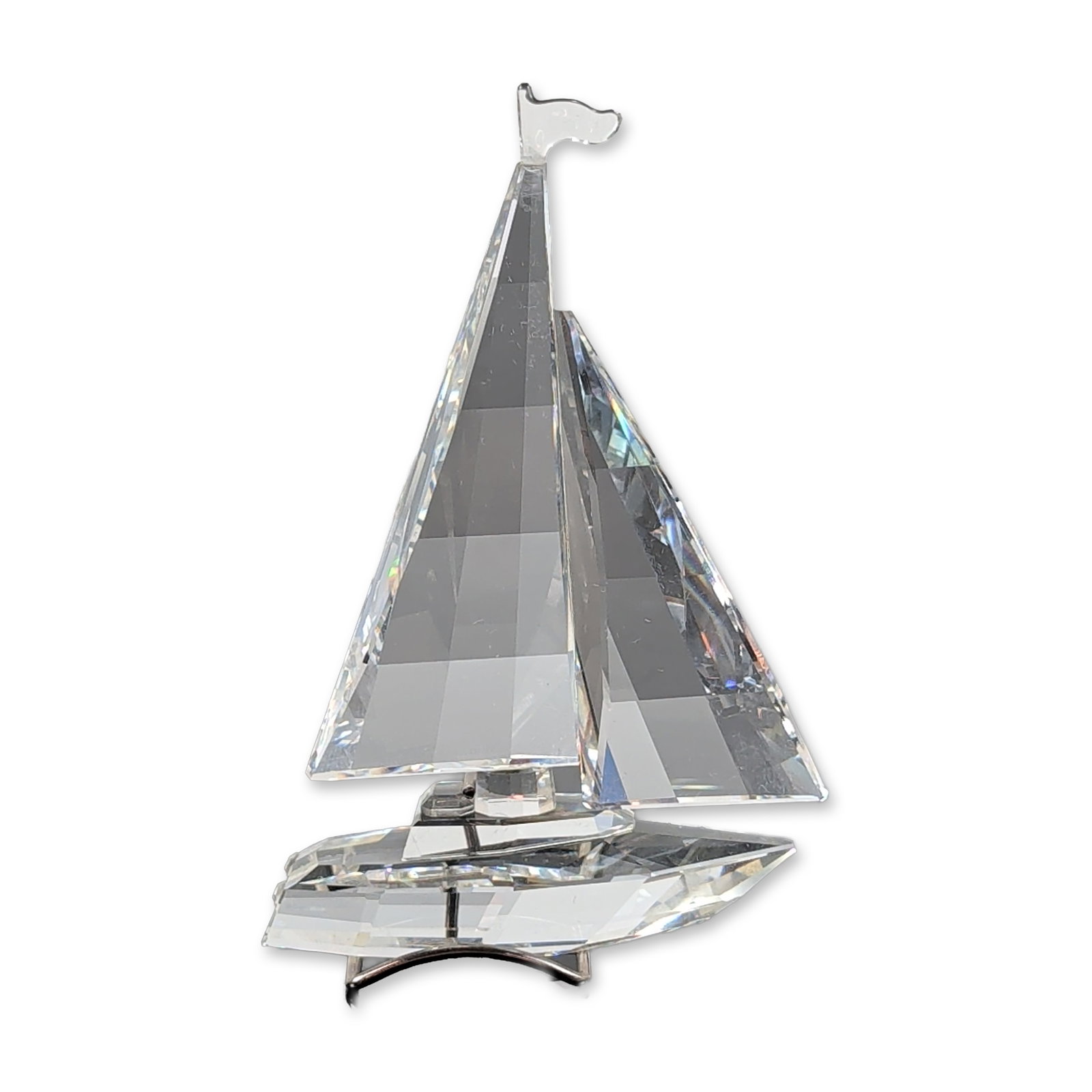 Swarovski Silver Crystal Sailboat Figurine: Swarovski. Sailboat figurine in faceted clear lead crystal and silver-tone metal stand, featuring faceted sails and a faceted hull. Includes etched swan logo and copyright symbol to the underside. Acc