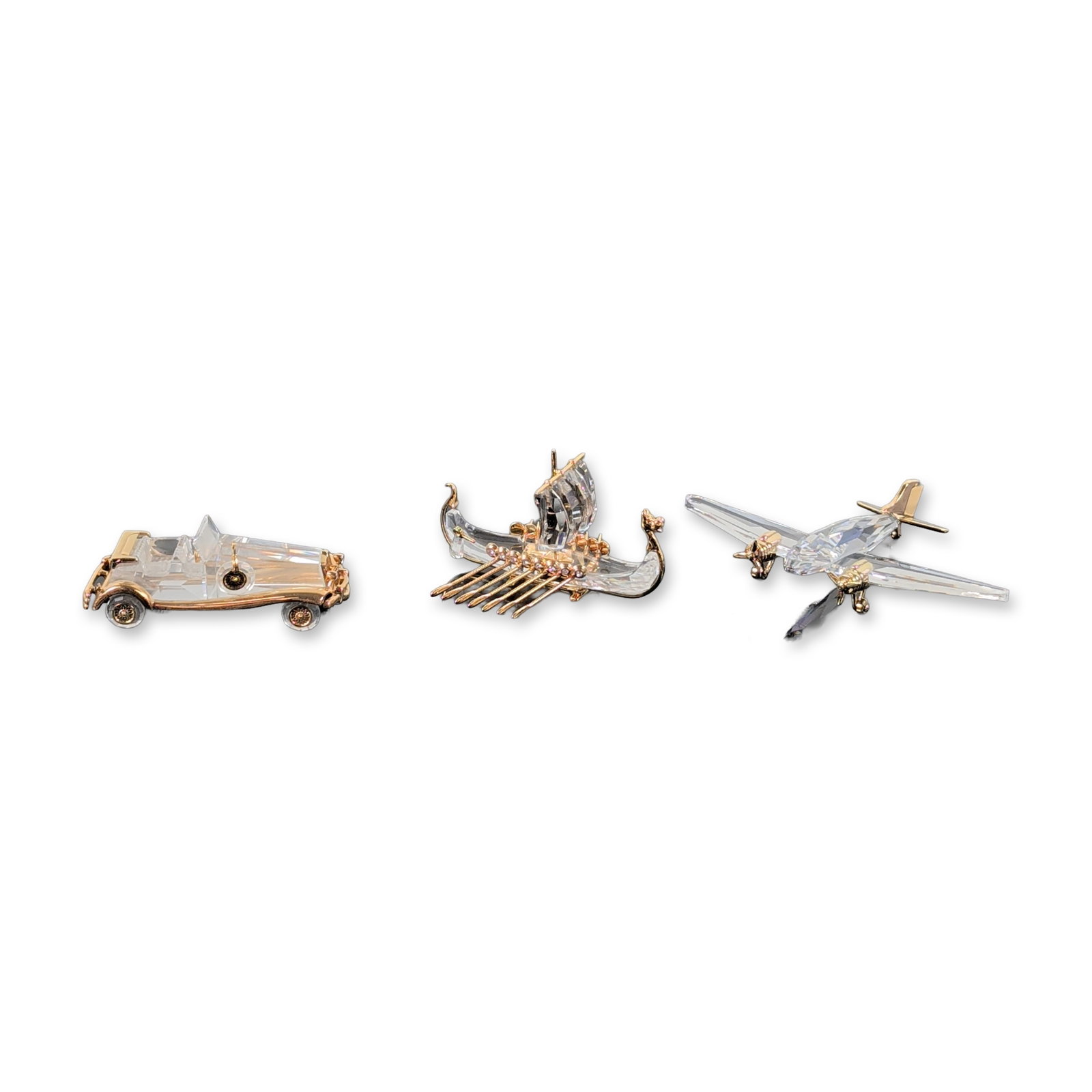 3pc Swarovski Crystal Memories Journeys Figurines: Swarovski. Trio of crystal figurines from the Crystal Memories Journeys series, featuring faceted clear lead crystal bodies and gold-plated metal accents. The collection includes a twin-engine propell