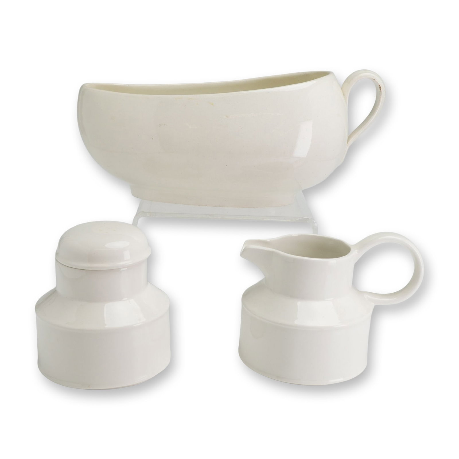 3pc Wedgwood and Midwinter English Ceramic Serving Pieces: A trio of mid-century modern English white glazed ceramic serving pieces. The grouping includes one sauce boat by Wedgwood featuring an elongated organic form with a pedestal base and single loop hand