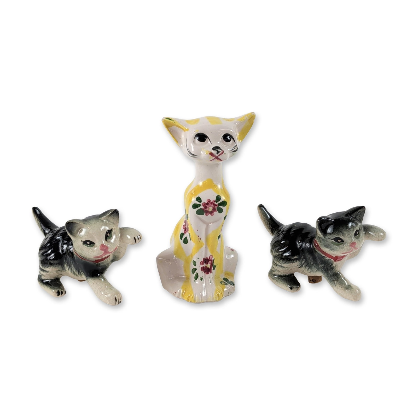 3pc Japanese Ceramic Cat Figurines: Mid-century Japanese export trio of cat figurines in glazed ceramic. The set comprises one tall, elongated feline and two smaller kittens in playful crouching poses. The tall cat features a white grou