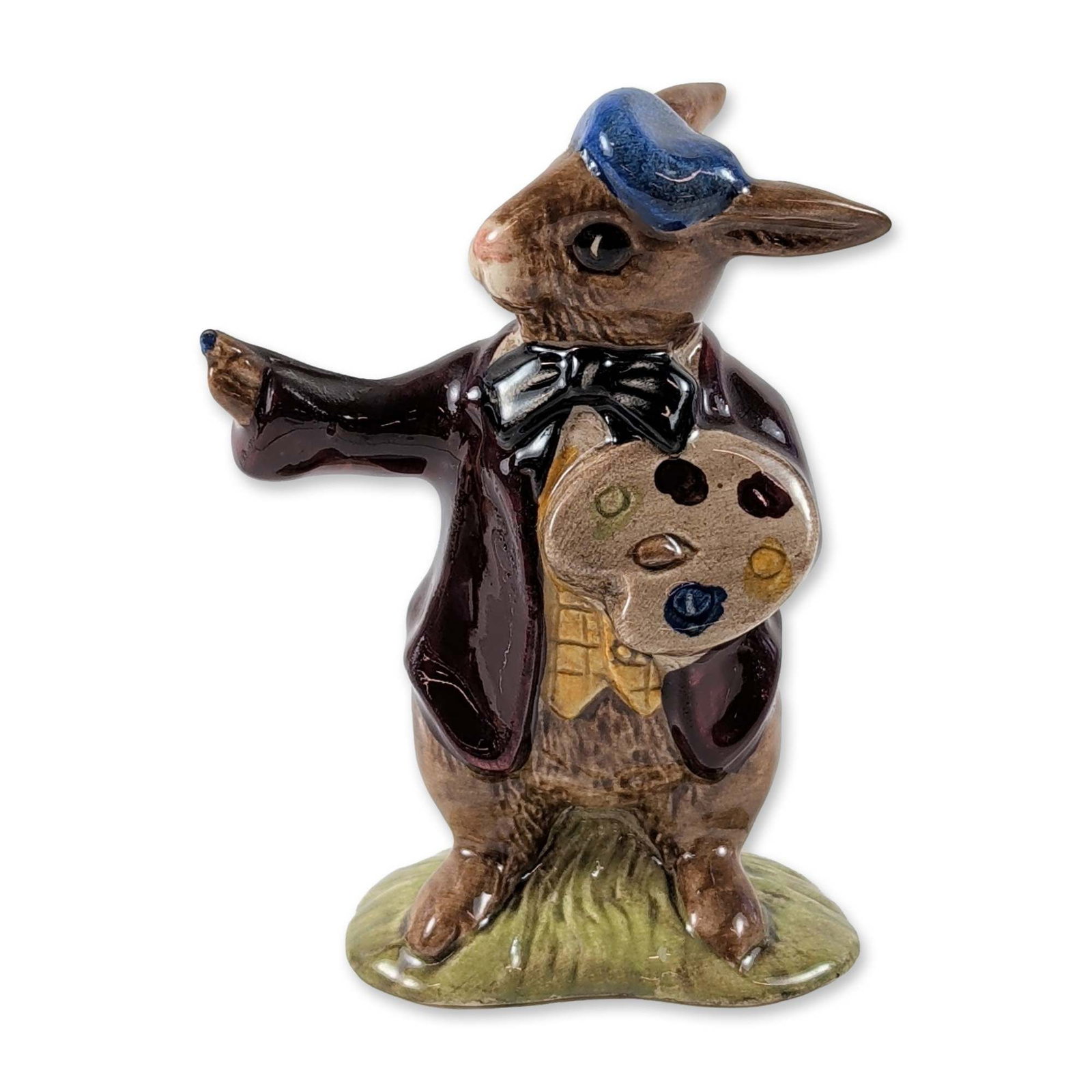 Royal Doulton Bunnykins The Artist Figurine DB13: Royal Doulton. Bunnykins glazed porcelain figurine titled The Artist, model number DB13, featuring a rabbit dressed in a brown frock coat, yellow patterned waistcoat, black bow tie, and blue beret, ho