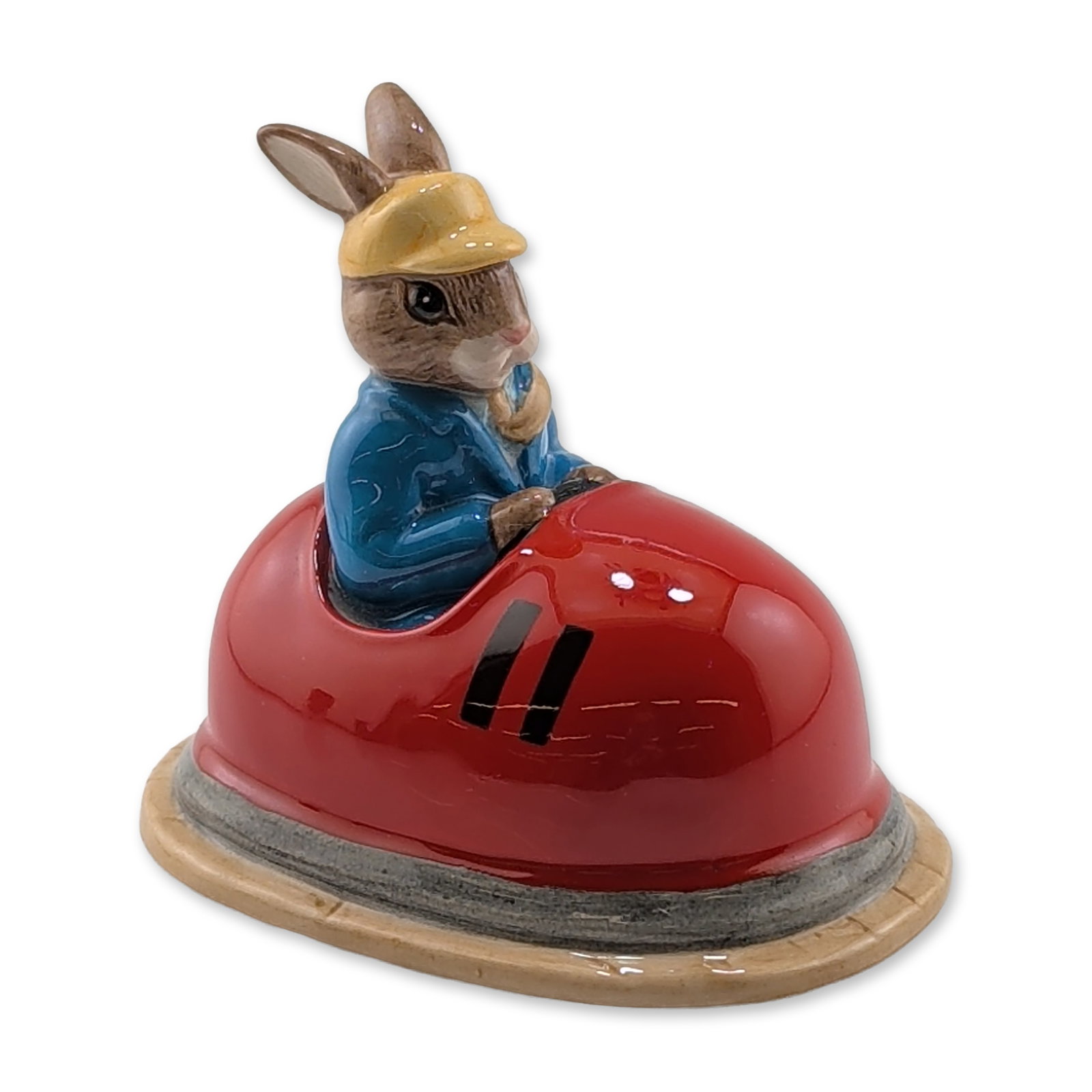 Royal Doulton Limited Edition Bunnykins Figurine, Dodgem DB249: Royal Doulton ceramic figurine, Dodgem Bunnykins, model DB 249. Hand-decorated glazed porcelain depicting a rabbit character in a blue jacket and yellow hat operating a red bumper car on a textured ta
