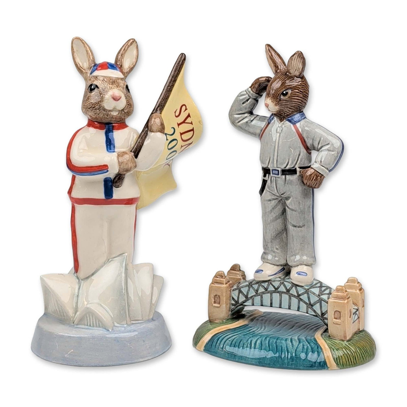 2pc Royal Doulton Sydney Bunnykins Figurines: Pair of Royal Doulton Bunnykins figurines in hand decorated earthenware, featuring two limited edition designs themed around Sydney, Australia. The first figure, titled Sydney Harbour Bridge Bunnykins