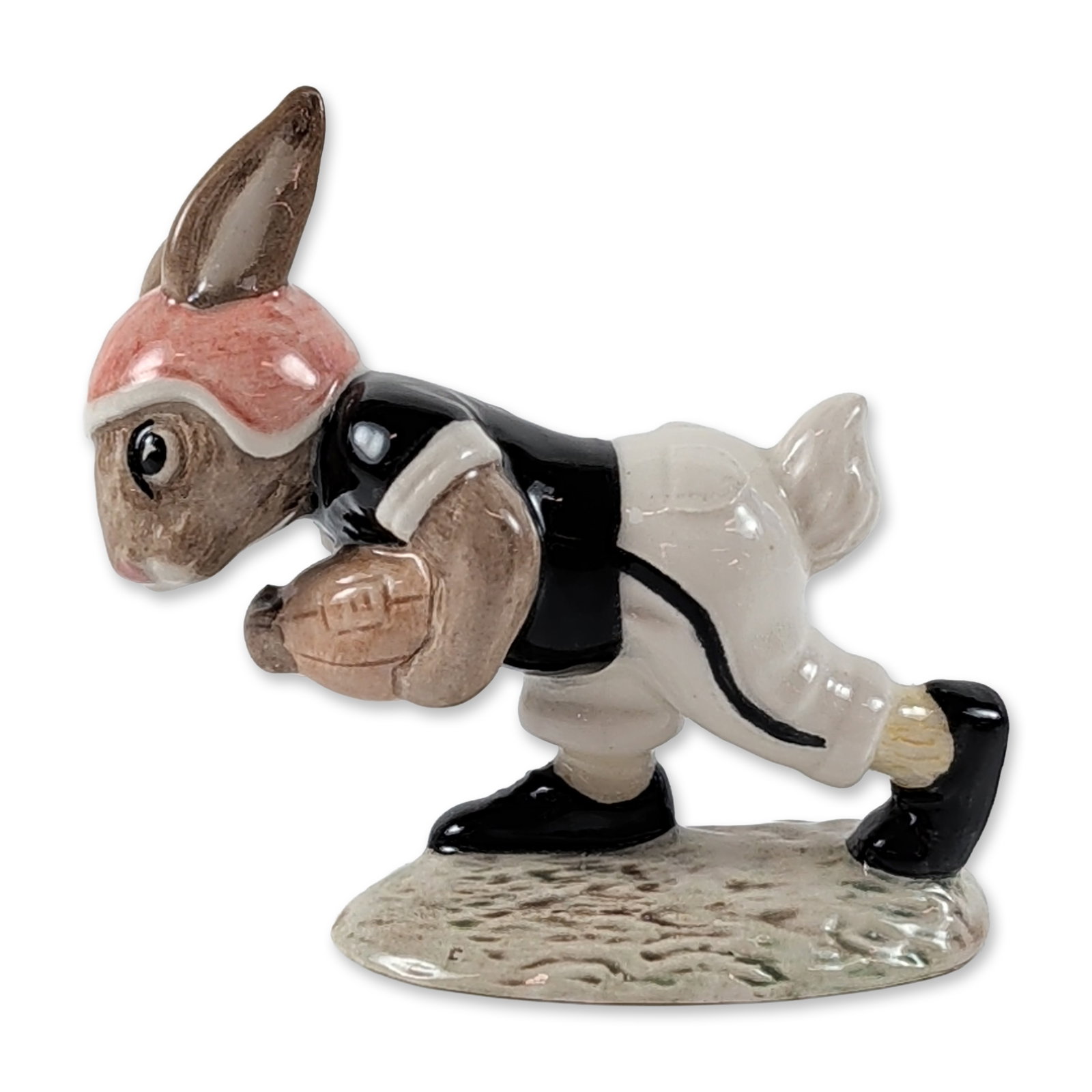Royal Doulton Touchdown Bunnykins Porcelain Figurine: Royal Doulton. Touchdown Bunnykins (DB 98) glazed porcelain figurine, featuring a rabbit character in an American football uniform. The figure is modeled in a dynamic diving pose clutching a brown foo