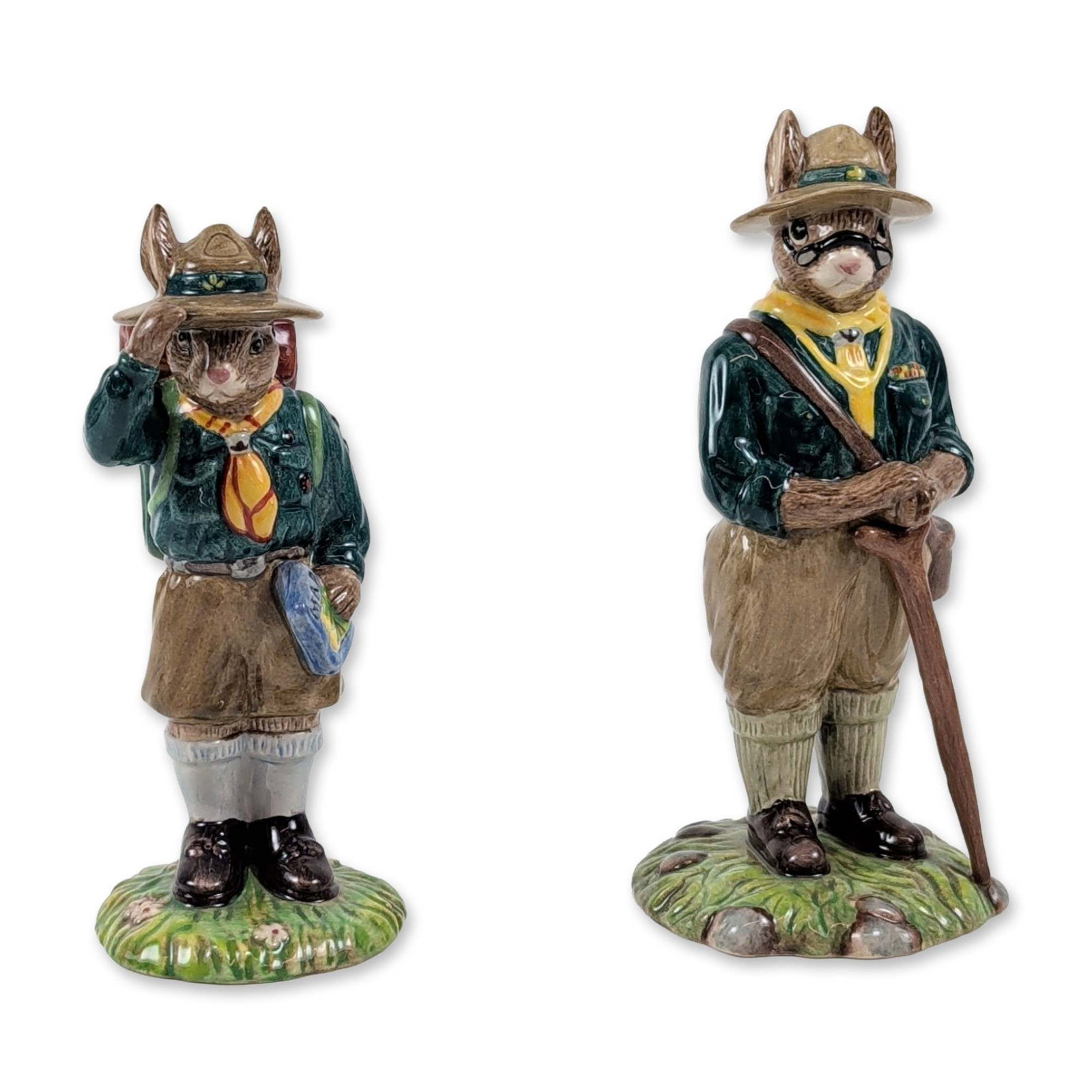 Pair of Royal Doulton Bunnykins Scouting Figurines: Pair of Royal Doulton Bunnykins ceramic figurines with scouting themes, produced in 2007. The first figurine, Scout Leader (DB 432), is modeled as an anthropomorphic rabbit in a dark green jacket, yel