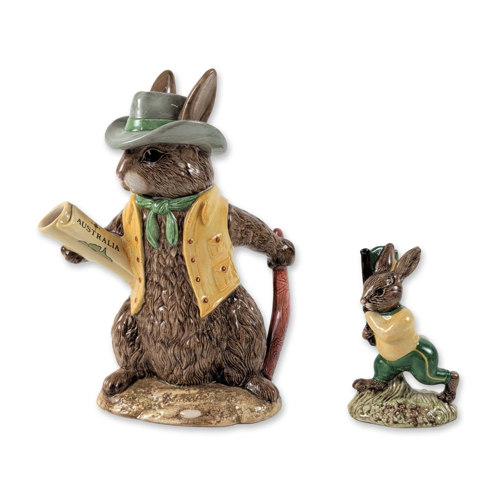 2pc Royal Doulton Aussie Explorer Teapot and Figurine: Royal Doulton. Two glazed ceramic items from the Bunnykins series with Australian commemorative themes. The first is a character teapot titled Aussie Explorer (D 7027) from the Bunnykins Teapots of th