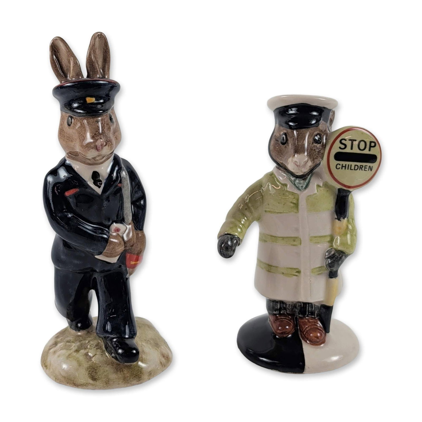 2pc Royal Doulton Bunnykins Ceramic Figurines: Royal Doulton, England. Two glazed ceramic figurines from the Bunnykins series. One figure, titled Lollipopman Bunnykins (DB 65), depicts a rabbit school crossing guard in a yellow and white striped c