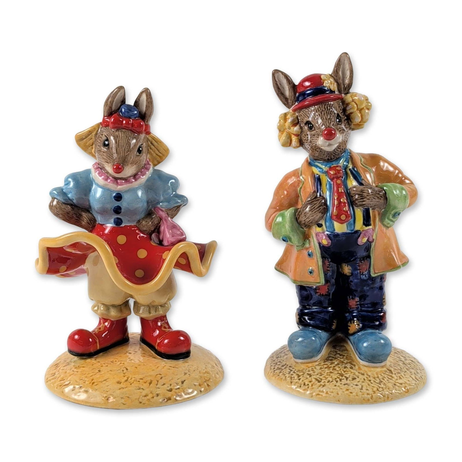 2pc Royal Doulton Bunnykins Clarence and Clarissa Clown Figurines: Royal Doulton. Pair of hand-painted ceramic figurines from the Bunnykins series, comprising Clarence the Clown (DB 332) and Clarissa the Clown (DB 331). The figures are modeled as anthropomorphic rabb