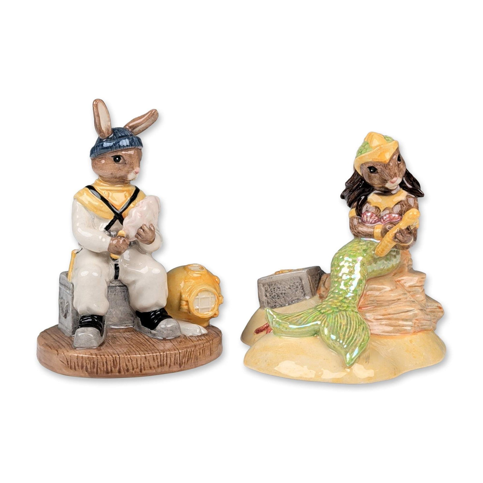 2pc Royal Doulton Bunnykins Figurines: Royal Doulton Bunnykins series. Pair of hand-painted glazed ceramic figurines with nautical themes. The Mermaid (DB 263) depicts a rabbit with a green iridescent tail holding a trident while reclining