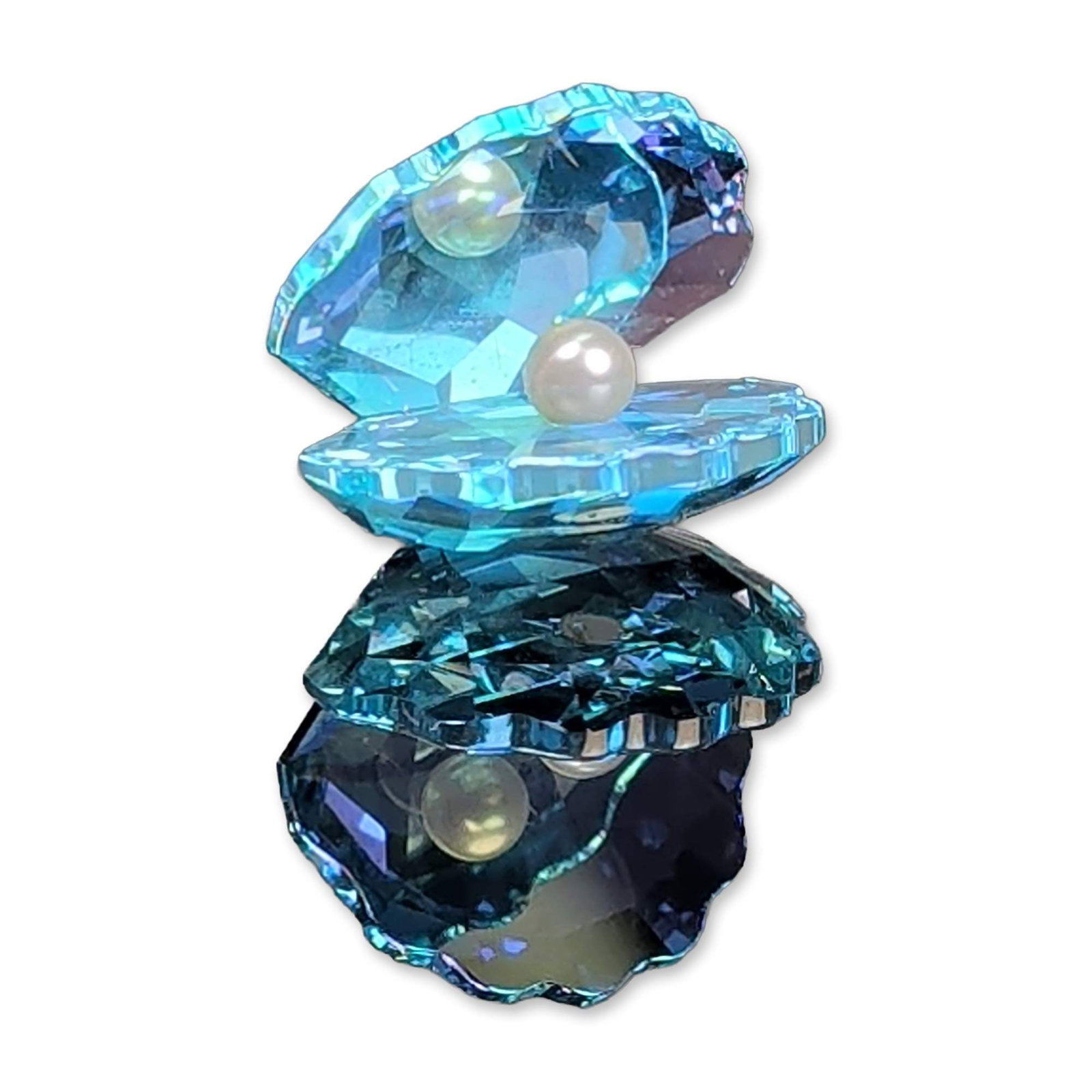 Swarovski Crystal Figurine, Light Aqua Blue Shell with Pearl: Swarovski. Clam shell figurine in faceted lead crystal featuring a color gradient from light aqua blue to navy blue. The piece consists of two joined open shells, each containing a single white faux p