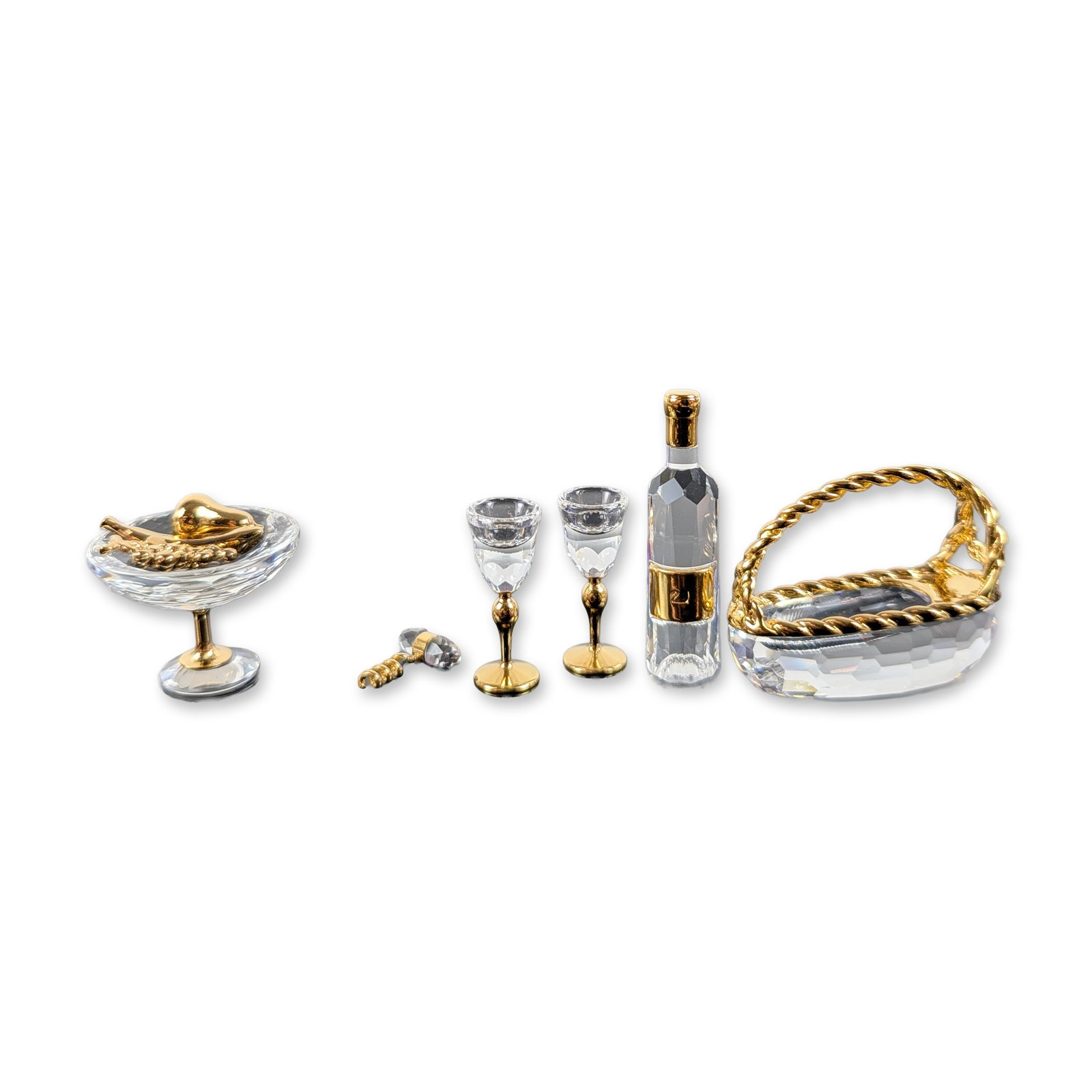 Swarovski Crystal Memories Miniature Grouping: Swarovski. Group of miniature figurines from the Crystal Memories Classics collection in faceted lead crystal and gold-plated metal. The collection includes a pedestal fruit bowl with loose gold-tone 