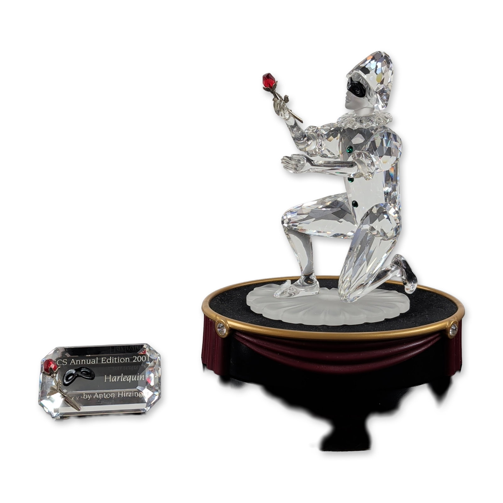 Swarovski SCS 2001 Harlequin Crystal Figurine with Title Plaque and Base: Swarovski. 2001 SCS Annual Edition Harlequin figurine in faceted lead crystal, representing the final piece of the Masquerade trilogy. The figure is depicted in a kneeling pose holding a rose with a r